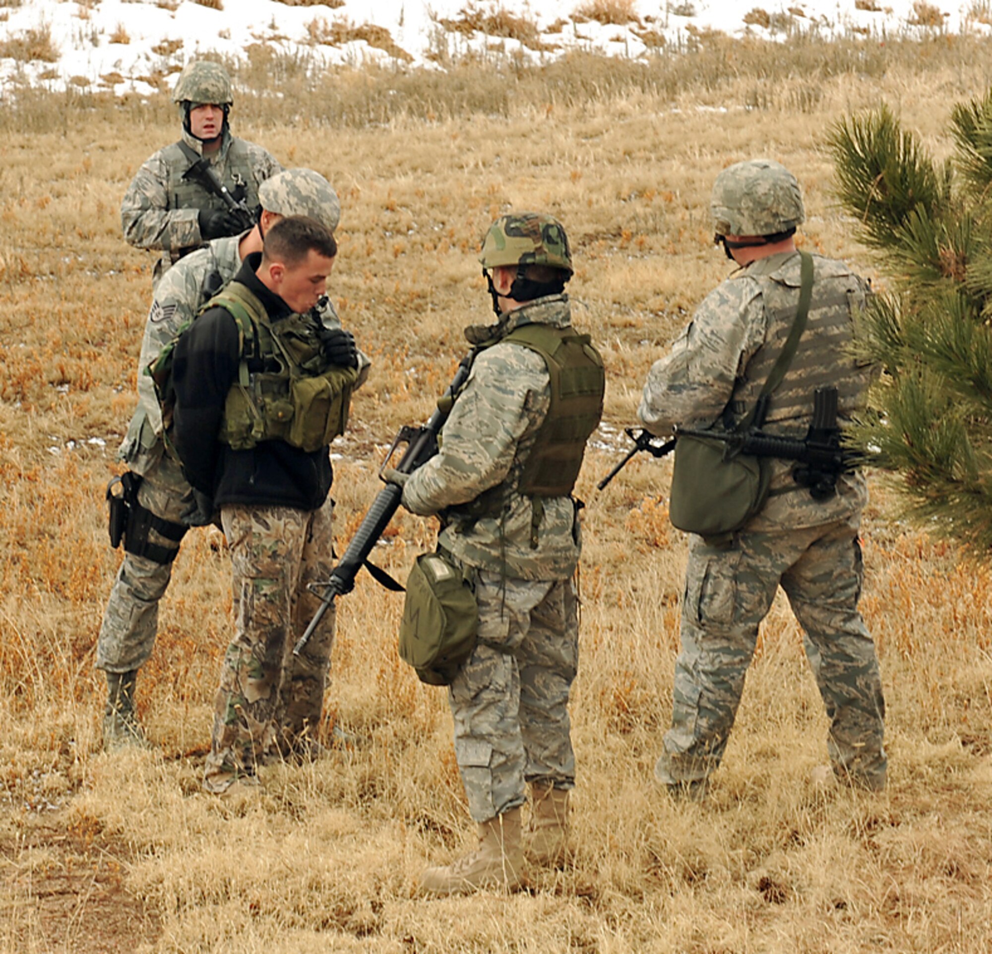 During the 21st Space Wing Condor Crest exercise, 21st Security Forces Squadron Airmen detain a shooting suspect (left) Feb. 25 in the wooded area behind the Peterson Shoppette. The active shooting scenario was part of the wing’s quarterly exercise. In this scenario, the gunman fired into a crowd of Airmen and civilians who had just evacuated Air Force Space Headquarters Building 1, near the north gate. The gunman was tackled and then removed from the parking lot to the wooded area by security forces. Condor Crest exercises also help ensure the 21st SW is able to complete its mission of professionally operating, supporting and protecting its personnel and resources during actual incidents. (U.S. Air Force photo/Roberta McDonald)