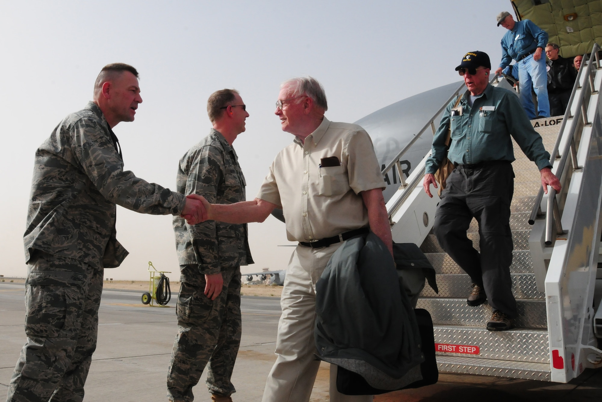 U.S. Air Force Col. Richard McComb, 386th Expeditionary Mission Support Group commander, welcomes Neil Armstrong and other "Legends of Aerospace" March 7, 2010 as they arrive at an air base in Southwest Asia. Mr. Armstrong and his fellow "Legends of Aerospace" are touring various military installations throughout Europe and Southwest Asia to share their groundbreaking aviation and aerospace experiences with those servicemembers serving overseas. (U.S. Air Force photo by Staff Sgt. Lakisha A. Croley/Released)