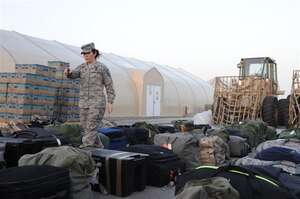 AL DHAFRA AIR BASE, United Arab Emirates -- Master Sgt. Wendi Atchley, deployed from Headquarters Air Combat Command A4, conducts a bag drag as a logistics plans specialist working with an expeditionary logistics readiness squadron. Sergeant Atchley is expected to return home in July. (Courtesy photo)