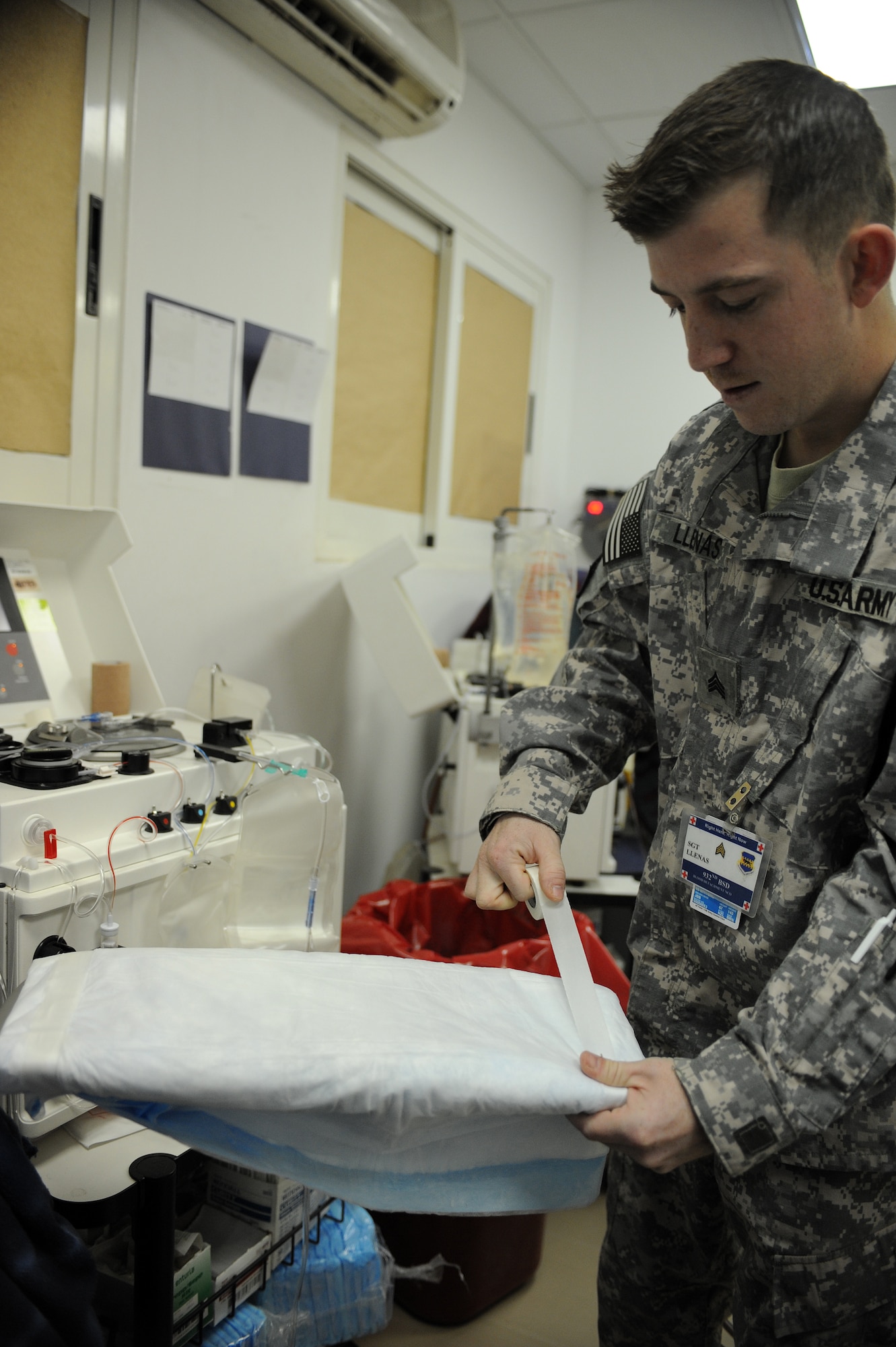 Sgt. Daniel Llenas, a lab technician with the 932nd Blood Support Detachment, prepares an arm resting table for a platelet donor at Joint Base Balad, Iraq, March 4, 2010. The technicians use an Apheresis machine that spins the blood and separates the platelets. The procedure takes approximately one and a half to two hours and the donor will receives back most of their blood. Sergeant Llenas is deployed from Fort Hood, Texas, and is a native of Juneau, Alaska. (U.S. Air Force photo by Master Sgt. Linda C. Miller/Released)