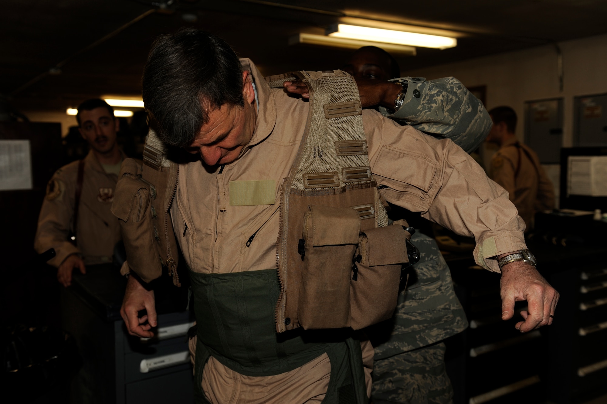 U.S. Air Force Staff Sgt. Willis Austin, 494th Expeditionary Fighter Squadron, helps U.S. Ambassador to Afghanistan Karl Eikenberry put on his survival vest at Bagram Airfield, Afghanistan, March 5, 2010. Ambassador Eikenberry was at Bagram to get an orientation flight in an F-15E Strike Eagle. Sergeant Austin is deployed from Royal Air Force Lakenheath, England and is from Laurens, S.C. (U.S. Air Force photo by/ Tech. Sgt. Jeromy K. Cross/released)