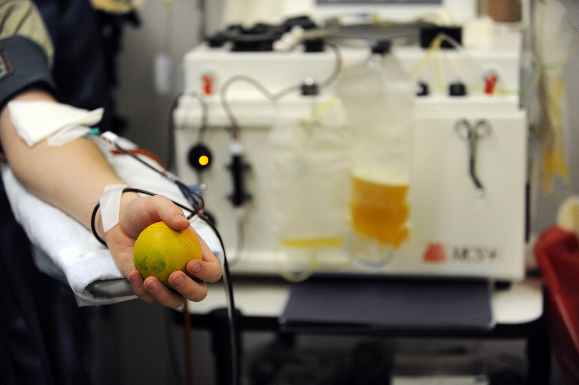 Staff Sgt. Ryan Eands, a surveillance technician with the 727th Expeditionary Air Control Squadron, holds a squishy stress ball during a platelet donation, at Joint Base Balad, Iraq, March 4, 2010. Sergeant Eands has made nine donations during his deployment. The procedure takes approximately one and a half to two hours and the donor will receives back most of their blood. Sergeant Eands is deployed from Hill Air Force Base, Utah, and is a native of Denver, Colo. (U.S. Air Force photo by Master Sgt. Linda C. Miller/Released)