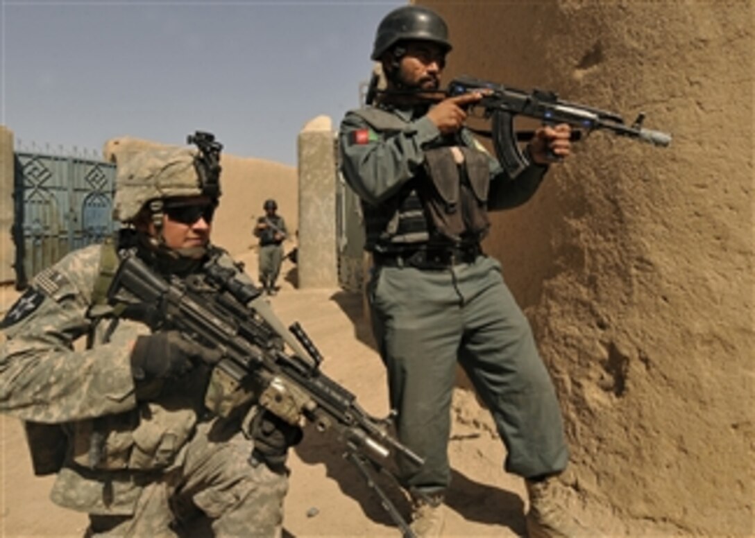 U.S. Army Pfc. Philip Pass, with Blackwatch Company, 2nd Battalion, 1st Infantry Regiment, and an Afghan National Policeman provide security during a joint patrol in the village of Pir Zadeh, Hutal province, Afghanistan, on March 6, 2010.  