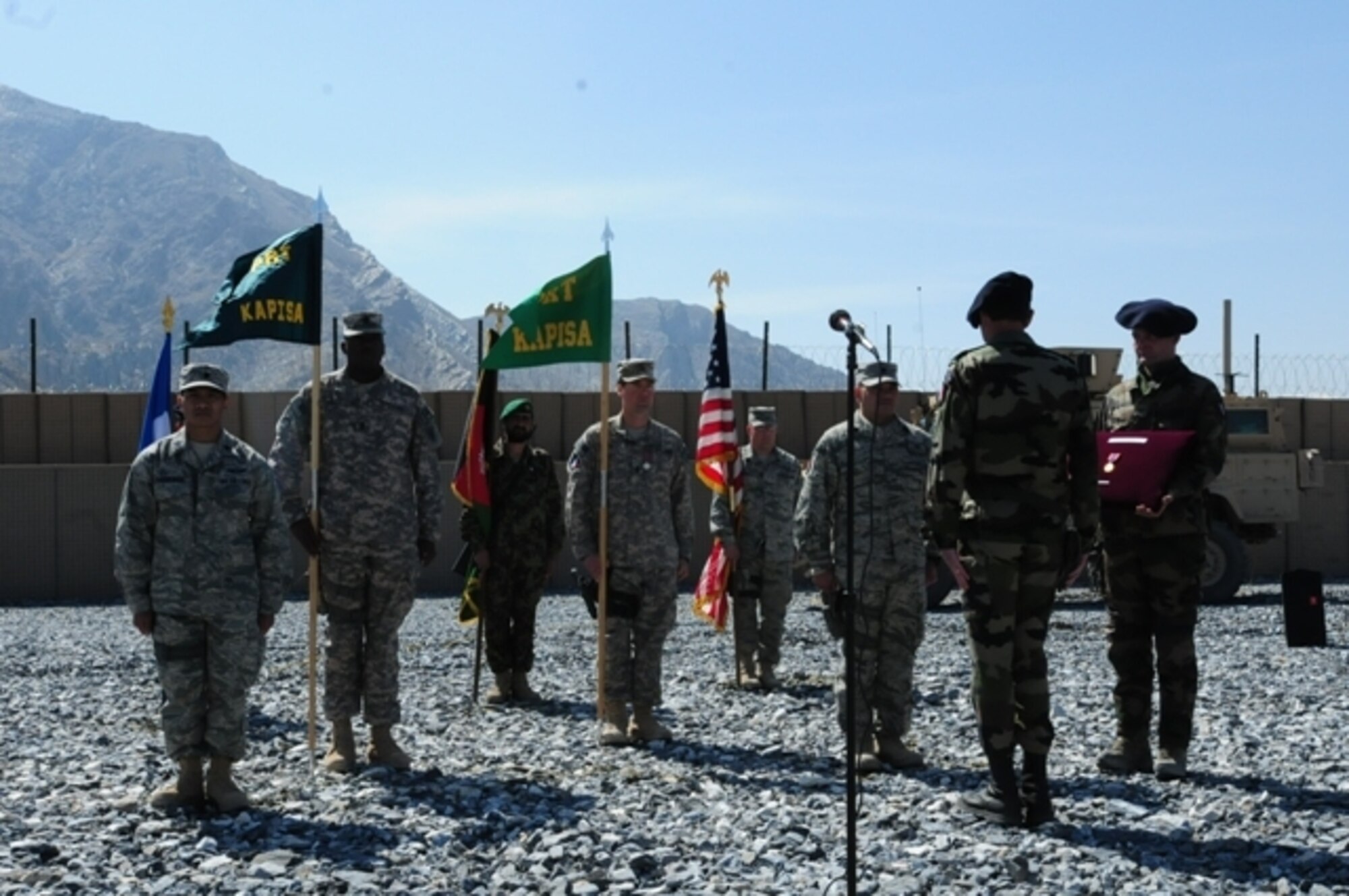 KAPISA PROVINCE, Afghanistan - U.S. Air Force Lt. Cols. Thomas Goulter and Joseph Paguiligan stand ready to transfer authority of Kapisa Provincial Reconstruction Team while U.S. Army Army 1st Sgts. Earl Jones and Edward Kelly bear the PRT guidons here at Forward Operating Base Morales-Frazier, Afghanistan, March 8. French Brig. Gen. Marcel Druart oversaw the transfer, combining the traditions of the U.S. Army, U.S. Air Force and French military during the ceremony. (Photo by U.S. Air Force 1st Lt. Michele M. Rollins, Kapisa Provincial Reconstruction Team Public Affairs) 