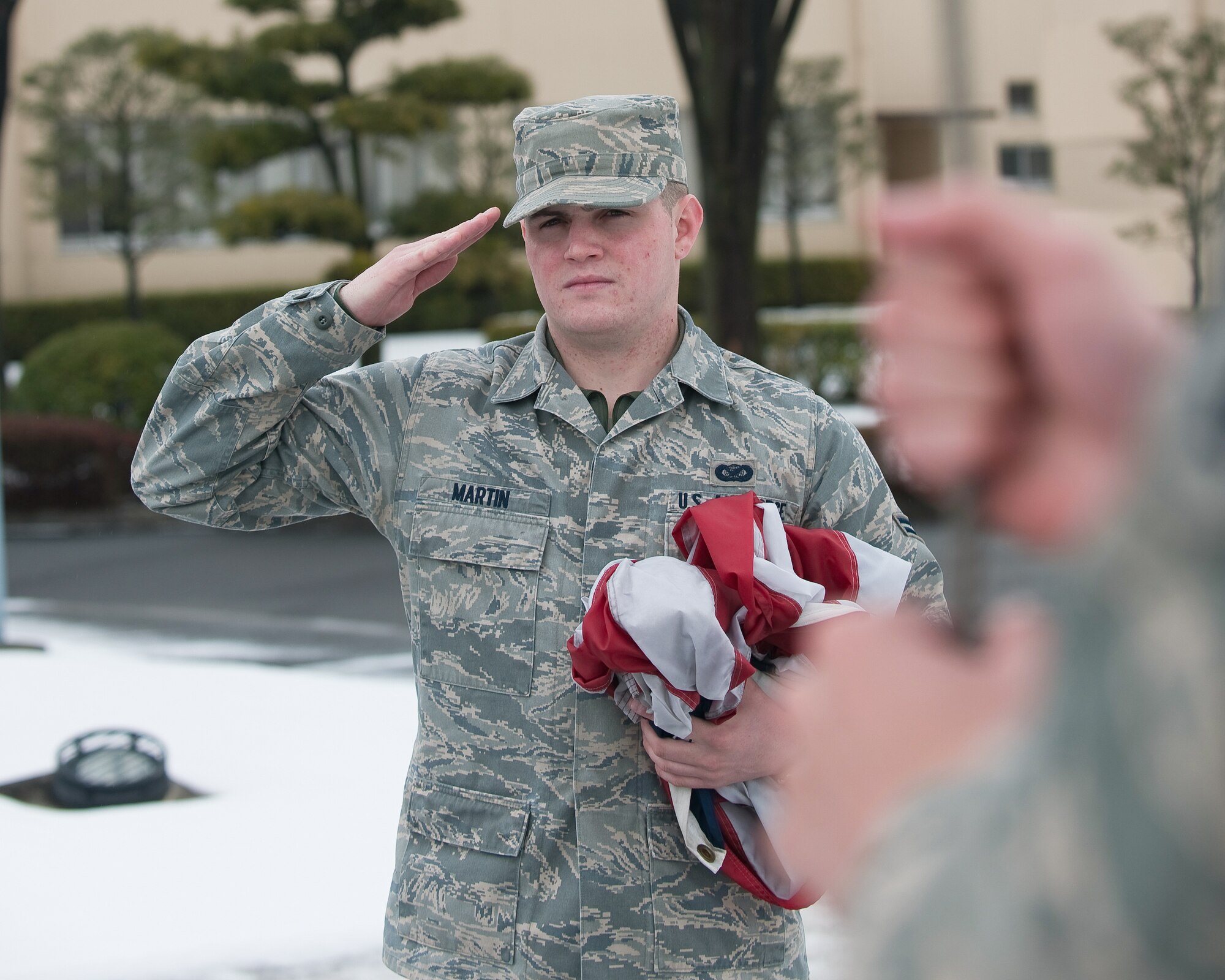 YOKOTA AIR BASE, Japan -- Airman 1st Class Sean Martin, 374th Airlift Wing, salutes the American flag March 10. The American flag is presented to Airmen upon retirement and symbolizes their service to the United States.  (U.S. Air Force photo/Osakabe Yasuo)

