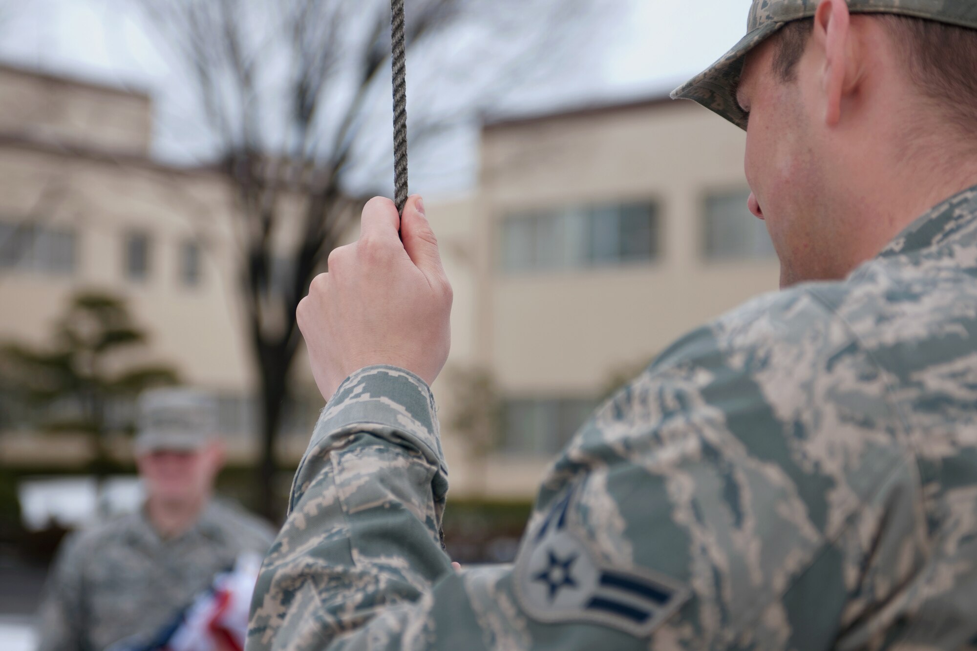YOKOTA AIR BASE, Japan -- Airman 1st Class Devin Doskey, 374th Airlift Wing, raises the American flag March 10.  The American flag is presented to Airmen upon retirement and symbolizes their service to their nation.  (U.S. Air Force photo/Osakabe Yasuo)