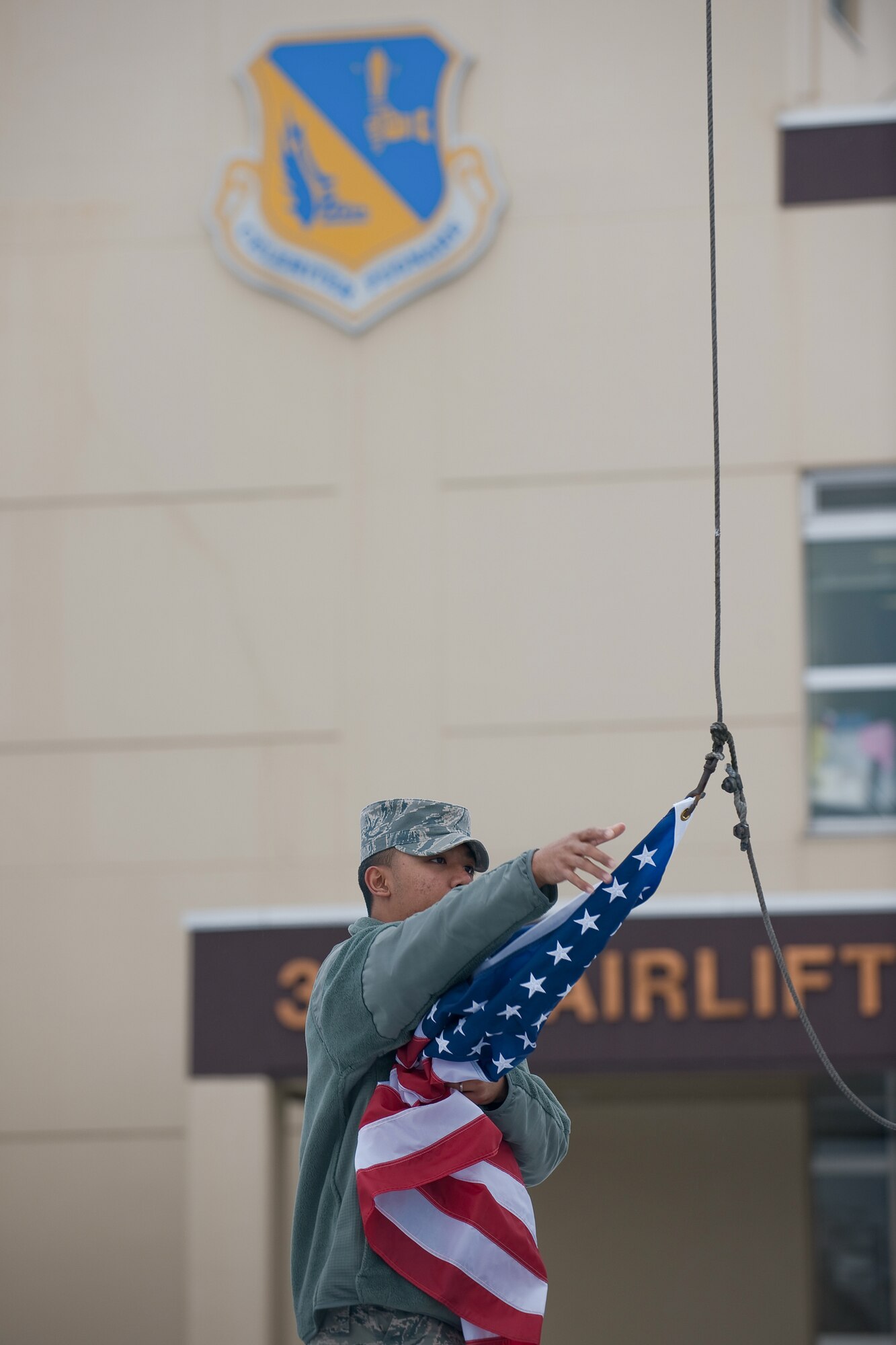 YOKOTA AIR BASE, Japan -- Senior Airman Mario Marquez, 374th Airlift Wing, secures the American flag March 10. Airman Marquez raised and lowered the flag during his duties for the base honor guard. The American flag is presented to Airmen upon retirement and symbolizes their service to the United States. (U.S. Air Force photo/Osakabe Yasuo)