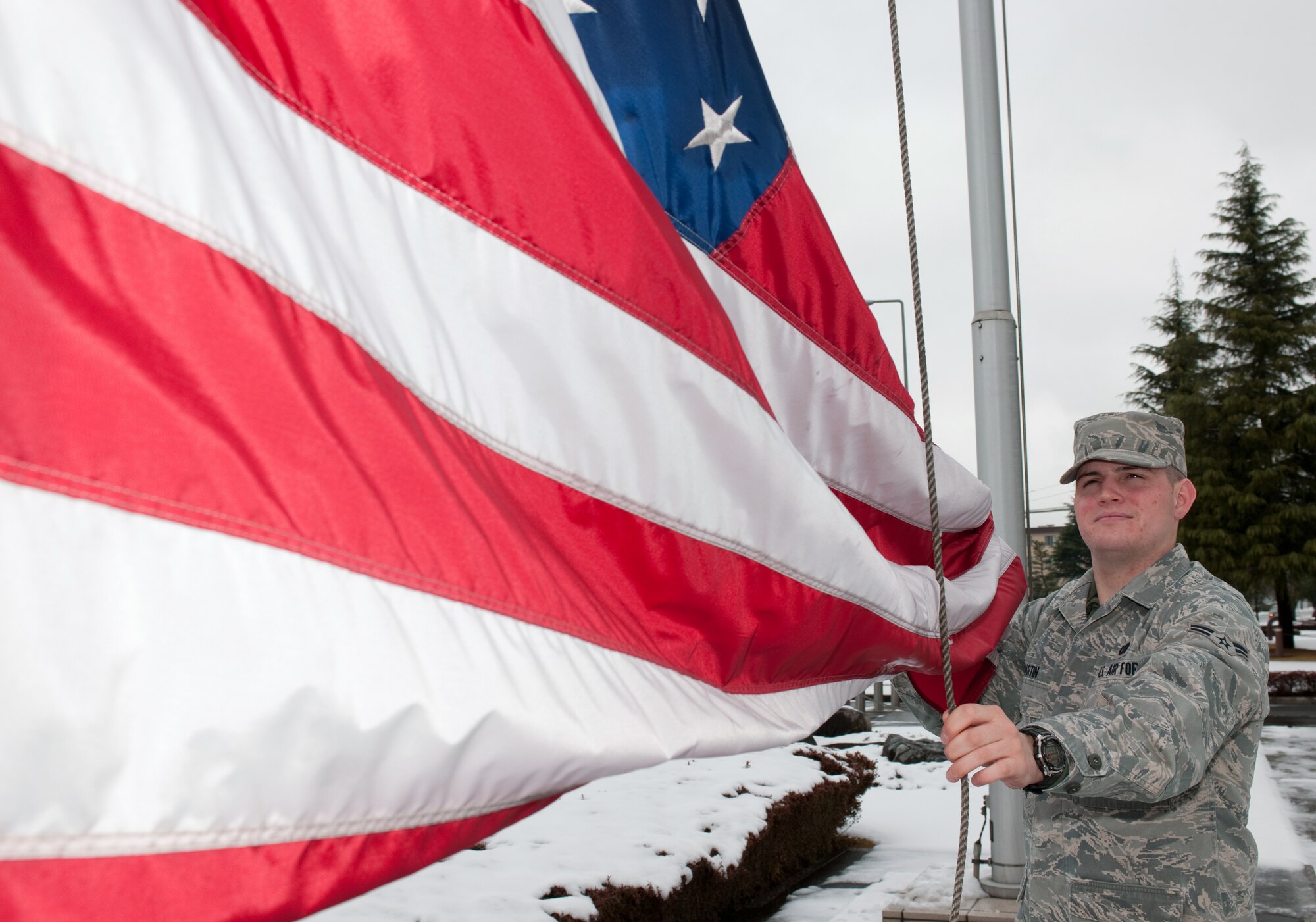 YOKOTA AIR BASE, Japan -- Airman 1st Class Sean Martin, secures the American flag March 10. Airman Martin raised and lowered the flag for the base honor guard. The American flag is presented to Airmen upon retirement and symbolizes their service to the United States. (U.S. Air Force photo/Osakabe Yasuo)
