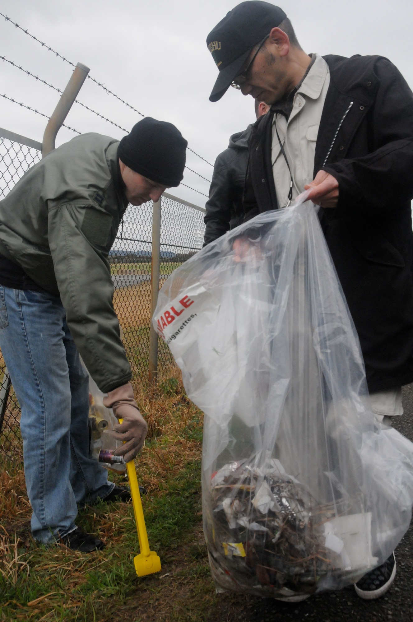TSUIKI CITY, Japan ? Capt. Trevor Boswell, 14th Fighter Squadron pilot, picks up trash with a member of the Kyushu Defense Bureau Office March 9, 2010. Airmen organized a park cleanup to help the local community. (U.S. Air Force photo/Staff Sgt. Rachel Martinez)