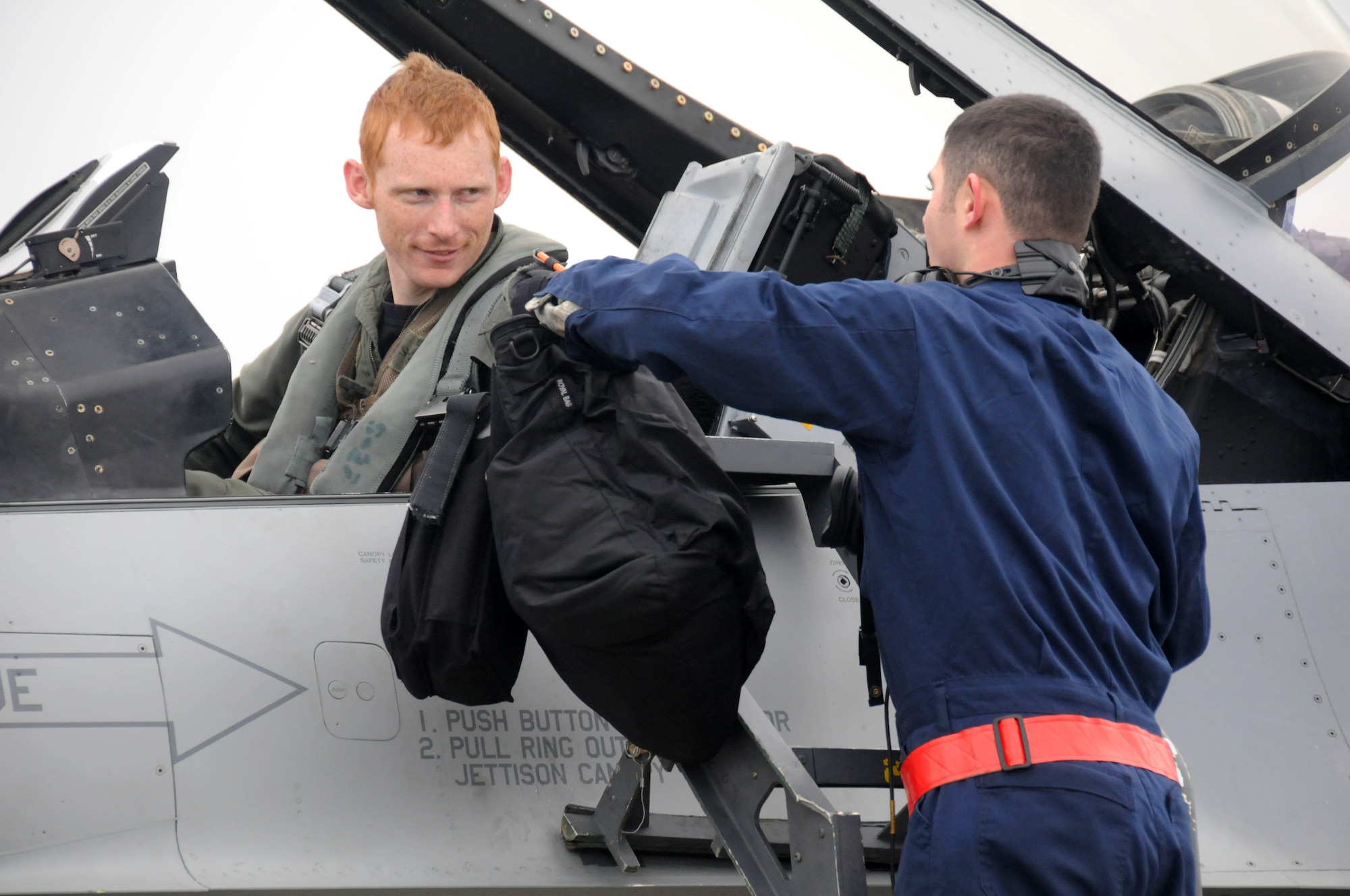 TSUIKI AIR BASE, Japan ? Capt. Eric Boyes, 14th Fighter Squadron pilot, hands his gear to Staff Sgt. Mario Almaraz, 35th Aircraft Maintenance Squadron crewchief, following an air-to-air training mission with Japan Air Self-Defense Force F-2s and F-15s March 8. The training is part of a week-long aviation training relocation exercise. (U.S. Air Force photo/Staff Sgt. Rachel Martinez)