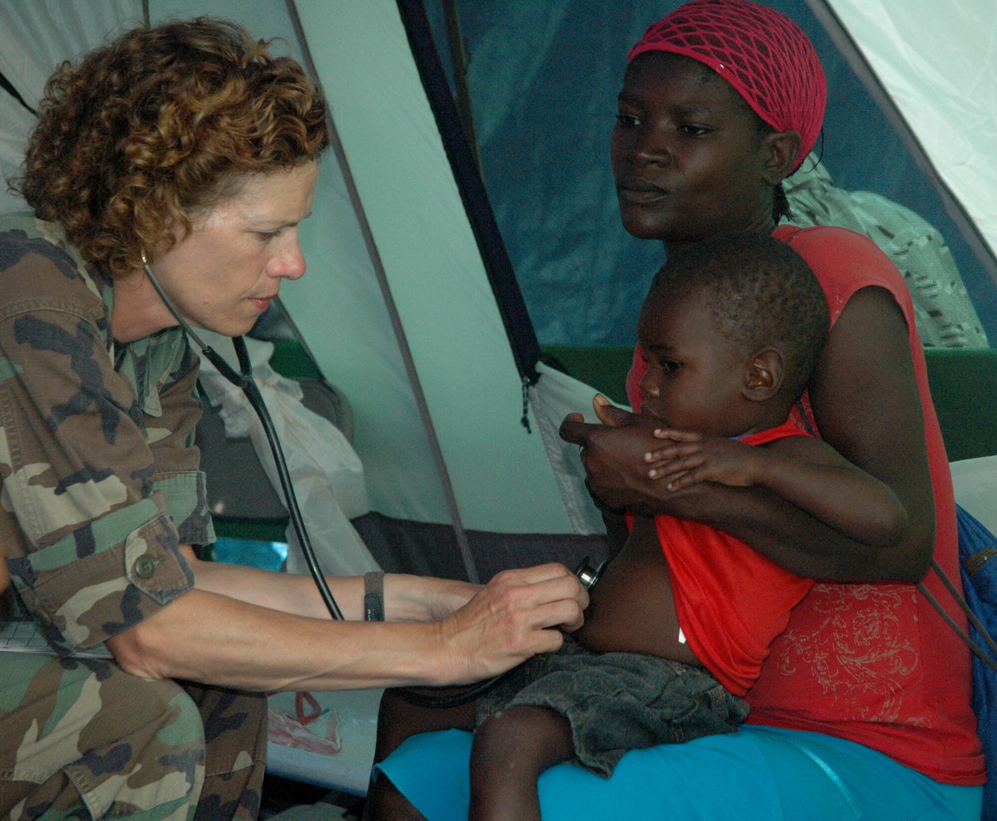 U.S. Air Force Col. Maggie Pelszynski, 24th Expeditionary Medical Support Squadron (EMEDS), examines a young Haitian boy in a tent set up at the Real Hope For Haiti Rescue Center in Cazale, Haiti. Airmen from EMEDS are assisting the rescue center by providing medical care to Haitians in need after the devastating earthquake hit Haiti Jan. 12.  (U.S. Air Force photo by 1st Lt. Cody Chiles/Released)