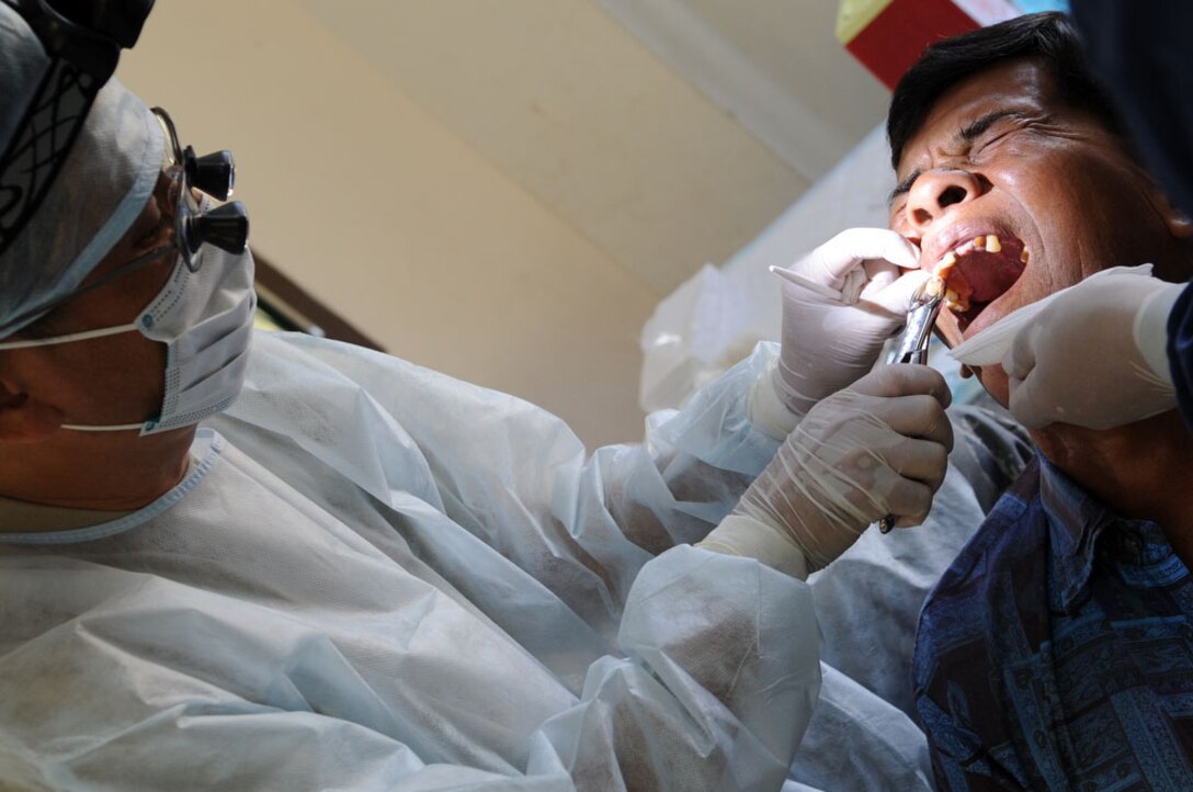 A local man has a tooth extracted by Maj. (Dr.) Kurt Nishiguchi March 4, 2010, at the Ban Nong Sroung School in Thailand. Doctor Nishiguchi is a reservist from Joint Base Pearl Harbor-Hickam, Hawaii. (U.S. Air Force photo/Tech. Sgt. Cohen A. Young)