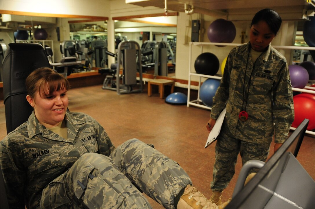 ELLSWORTH AIR FORCE BASE, S.D. -- (Left to right) Airman Kaitlin Walker, 28th Bomb Wing radio and television broadcaster, puts her leg muscles to the test as Airman 1st Class Elimae Gilchrist, 28th Force Support Squadron fitness specialist, tracks her results during a fitness assessment, March 9.  The leg press tones both leg and abdomen muscles which can improve run times. (U.S. Air Force photo/Airman 1st Class Anthony Sanchelli)