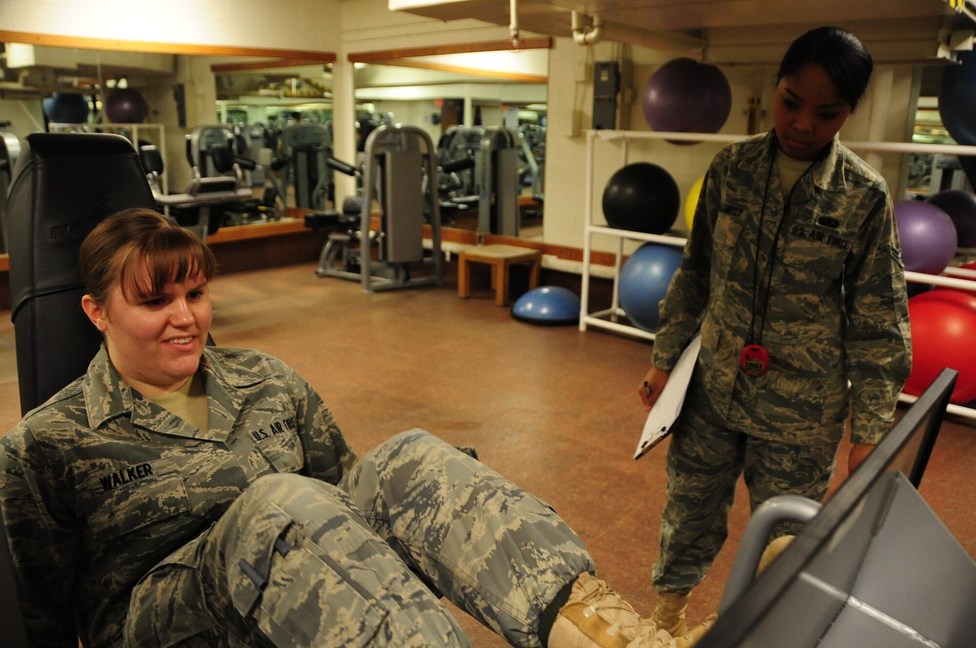 ELLSWORTH AIR FORCE BASE, S.D. -- (Left to right) Airman Kaitlin Walker, 28th Bomb Wing radio and television broadcaster, puts her leg muscles to the test as Airman 1st Class Elimae Gilchrist, 28th Force Support Squadron fitness specialist, tracks her results during a fitness assessment, March 9.  The leg press tones both leg and abdomen muscles which can improve run times. (U.S. Air Force photo/Airman 1st Class Anthony Sanchelli)