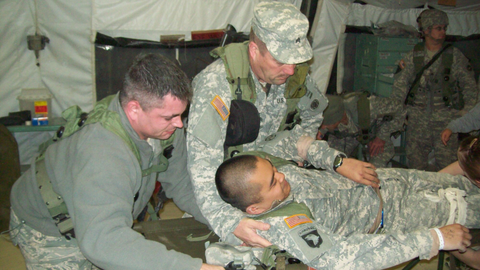 FORT POLK, La. -- 1st Lt. Corbin McCabe, 932nd Aeromedical Evacuation Liasion Team memeber, assists an Army sergeant in hosting a patient onto a bed during a Joint Readiness Training Exercise. Lieutenant McCabe along with six other members of the 932nd Airlift Wing participated in the 10 day long exercise. (Courtesy Photo)