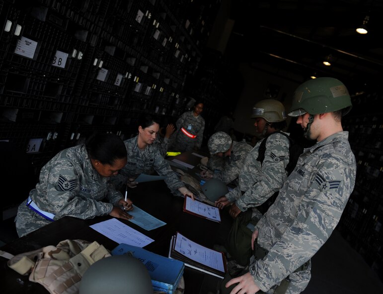 MOODY AIR FORCE BASE, Ga. -- Moody members who are processing through the deployment line wait as their paperwork is checked by an Airman from the 23rd Logistics Readiness Squadron individual protective equipment section during a Phase I Operational Readiness Inspection here March 9. Airmen are required to carry certain personal and duty-related items with them when they deploy. (U.S. Air Force photo by Senior Airman Gina Chiaverotti-Paige)