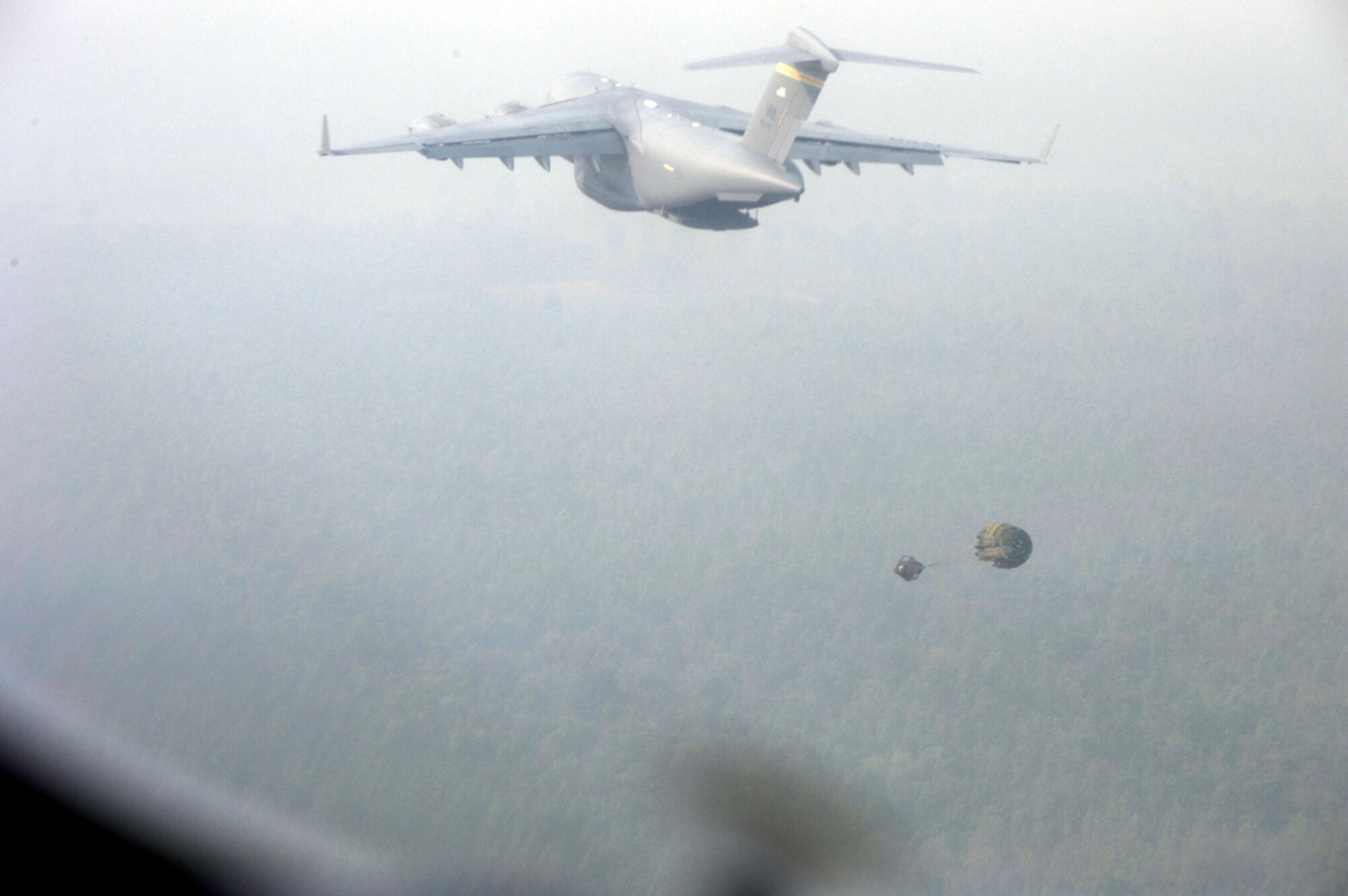 Simulated cargo is ejected from the back of a C-17 Globemaster III during an airdrop training mission supporting Cope Tiger 2010 March 8, 2010, in Thailand. The C-17 is from Joint Base Pearl Harbor Hickam, Hawaii. The C-17 is from the (U.S. Air Force photo/Tech. Sgt. Cohen A. Young)