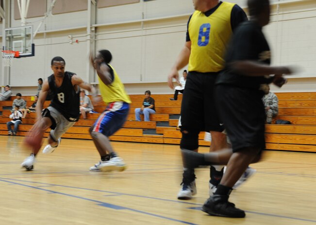 Gregory Bouie dribbles the ball past a defender during an intramural basketball game held at the Fitness and Sports Center here March 9. The 628th Security Forces Squadron beat the 437th Operations Support Squadron 41-36. Bouie is with the 628 SFS. (U.S. Air Force photo/Senior Airman Katie Gieratz)