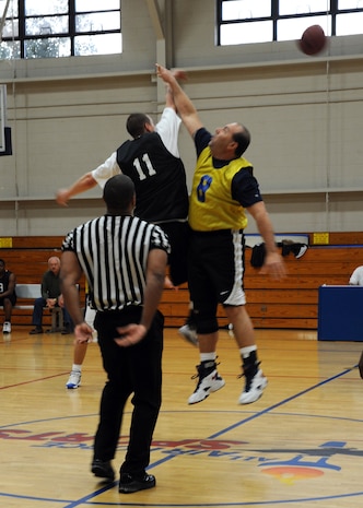 Geoffrey Smart and Humberto Camara both jump for the tip off at the beginning of an intramural basketball game held at the Fitness and Sports Center here March 9. The 628th Security Forces Squadron won the game against the 437th Operations Support Squadron 41-36. Smart is with the 628 SFS and Camara is with the 437 OSS. (U.S. Air Force photo/Senior Airman Katie Gieratz)