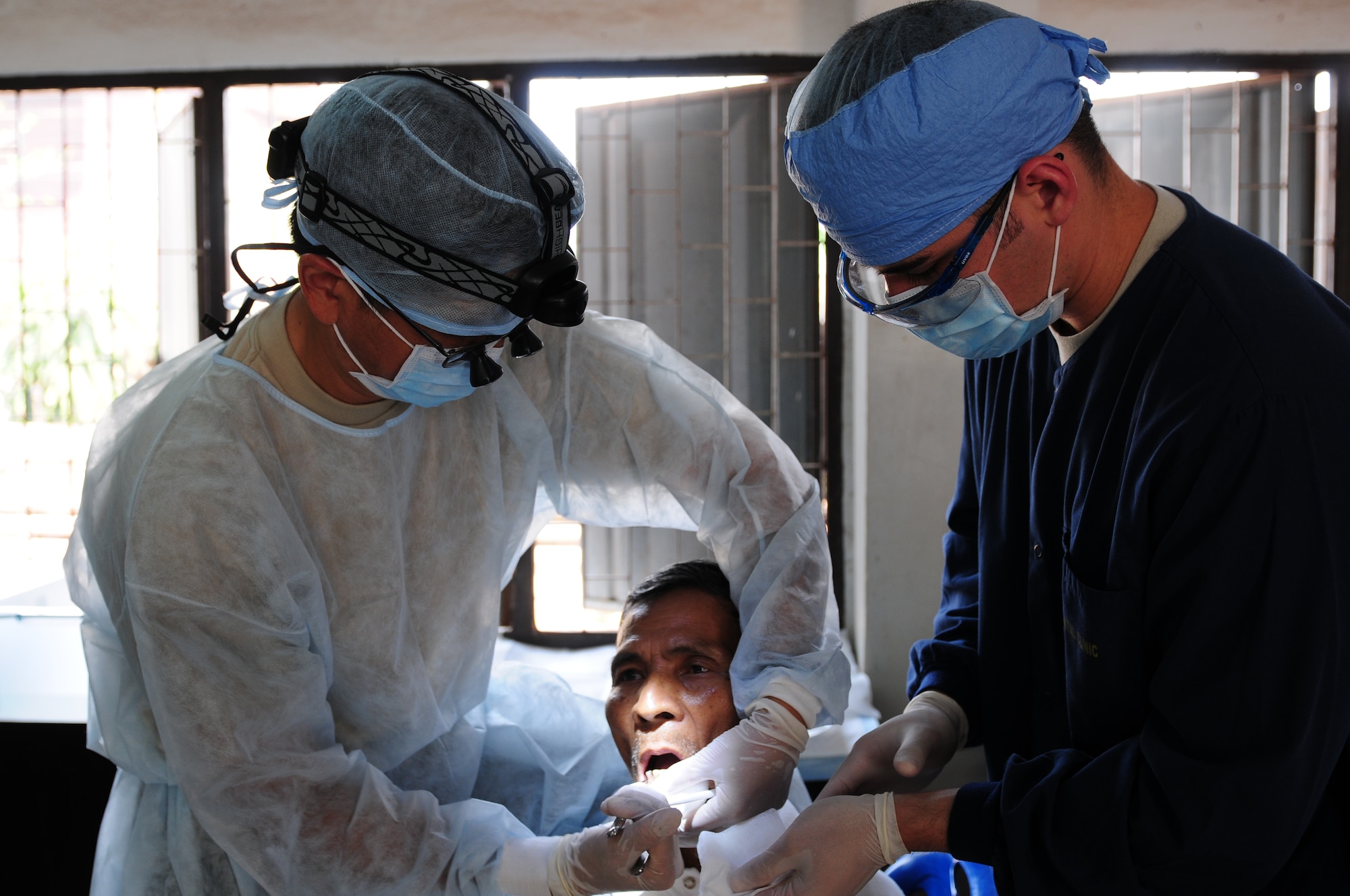 Maj. (Dr.) Kurt Nishiguchi, a dentist from the 624th Aeromedical Dental Squadron at Joint Base Pearl Harbor Hickam, Hawaii and Staff Sgt. Vincent Nelson, a dental assistant from 724th Aeromedical Dental Squadron at Andersen Air Force Base, Guam, perform a tooth extraction on a local Thai man during a medical civic assistance program being conducted in Thailand as part of exercise Cope Tiger 2010. Cope Tiger is an annual, multilateral field-training exercise involving the U.S. Air Force, Royal Thai Air Force and Army and the Republic of Singapore Air Force. This year’s exercise is being held at Korat and Udon Thani Royal Thai Air Force Bases in Thailand, March 1-12.  The exercise enhances combined readiness and interoperability between the United States and countries throughout the Asia-Pacific region. (U.S. Air Force photo/Capt. Genieve David)
