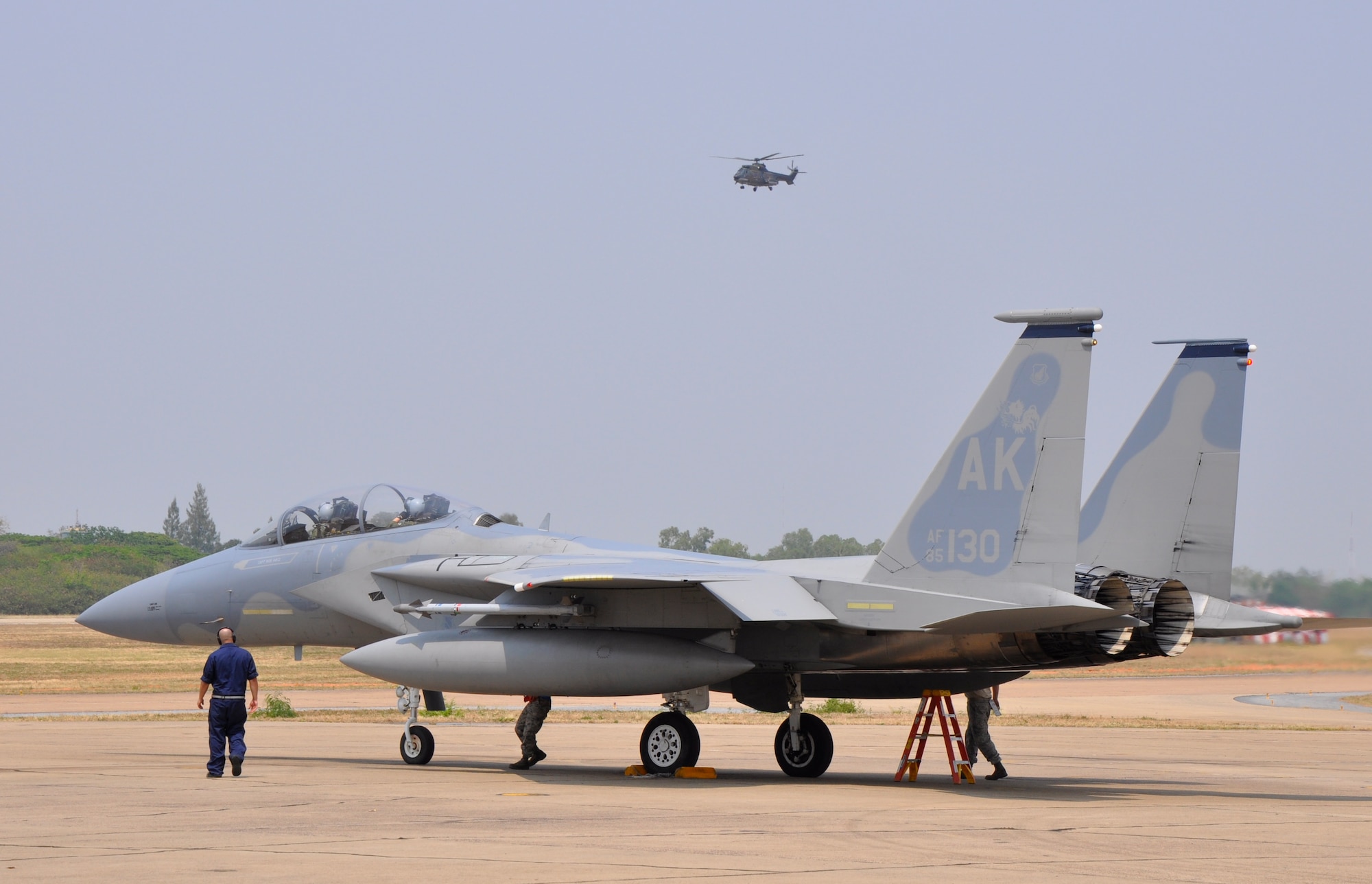 A Republic of Singapore Air Force Super Puma helicopter hovers overhead as a U.S. Air Force F-15 Eagle prepares to take off for an afternoon mission at Korat Royal Thai Air Force Base, Thailand, March 9.  U.S., Singapore and Thai air forces are participating in exercise Cope Tiger 2010, a multilateral aerial large force exercise that takes place annually. Approximately 500 U.S. Airmen are participating in this year’s exercise, which runs from March 1-12. (U.S. Air Force photo/Capt. Christy Stravolo)
