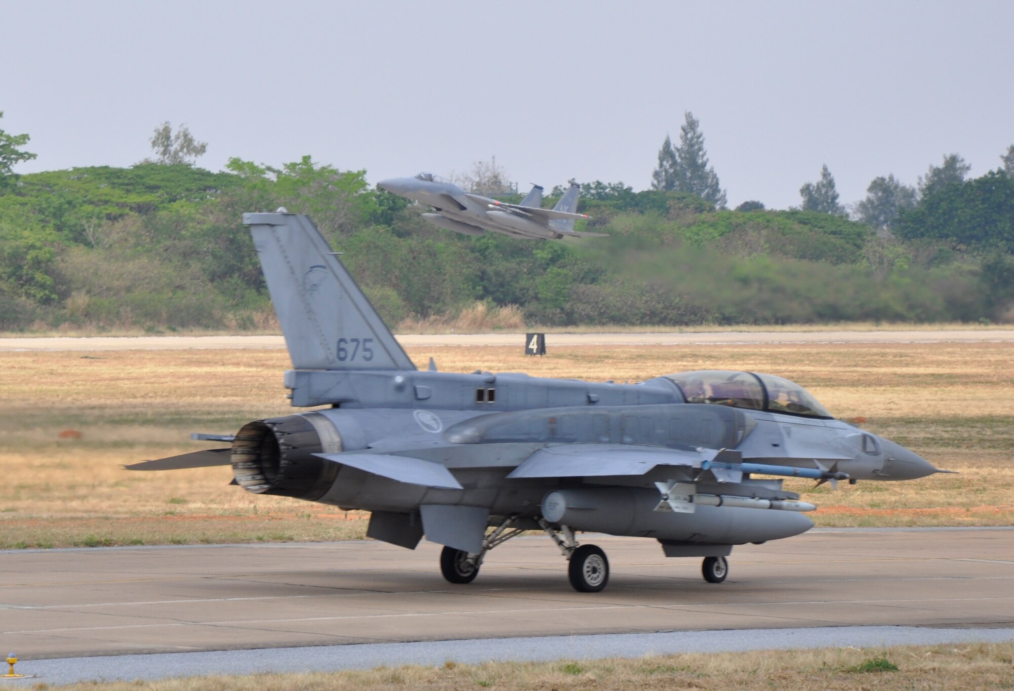 A Republic of Singapore Air Force F-16 Fighting Falcon and a U.S. Air Force F-15 Eagle takes off from Korat Royal Thai Air Force Base, Thailand, as they participate in exercise Cope Tiger 2010, March 9. Cope Tiger is an annual, multilateral large-force exercise conducted in the Asia-Pacific region involving the U.S., Singapore and Thai air forces. The exercise enhances combined readiness and interoperability between the United States and countries throughout the Asia-Pacific region. This year’s exercise takes place March 1-12. (U.S. Air Force photo/Capt. Christy Stravolo)
