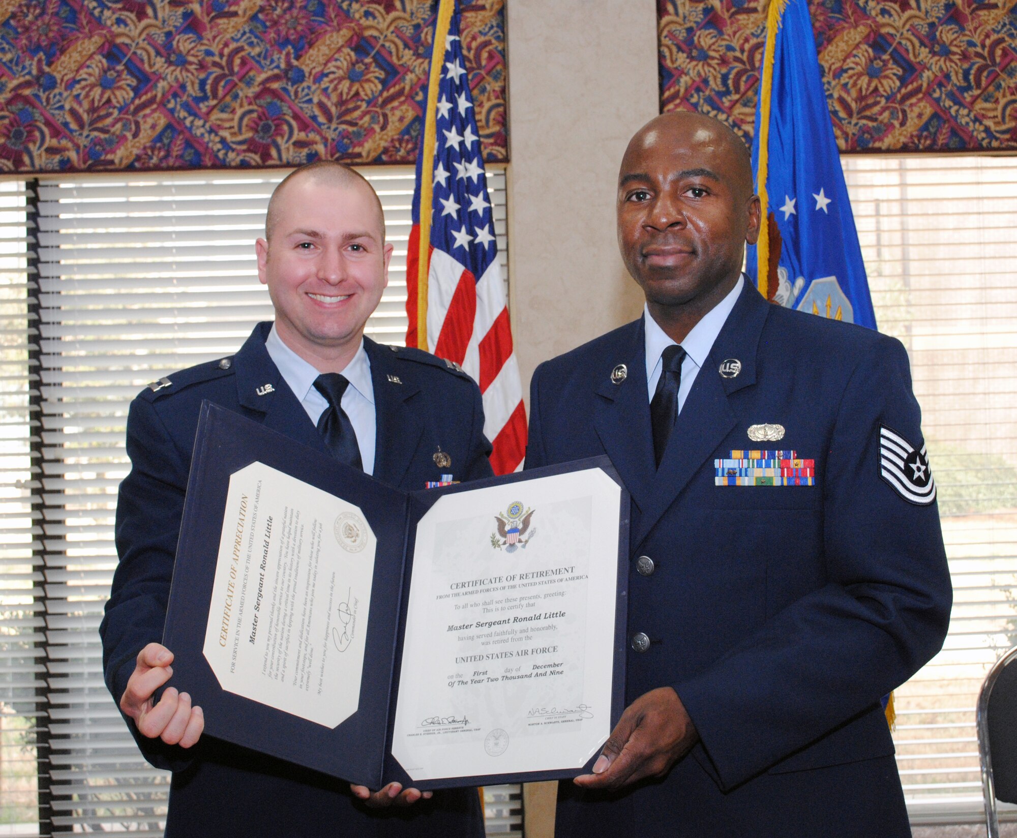 Tech. Sgt. Danny Griffin, 94th Services unit training manager, proudly displays the Air Force Certificate of Retirement presented by Capt. Nicholas Franz, 94th Services commander.  (U.S. Air Force photo/Master Sgt. Stan Coleman)