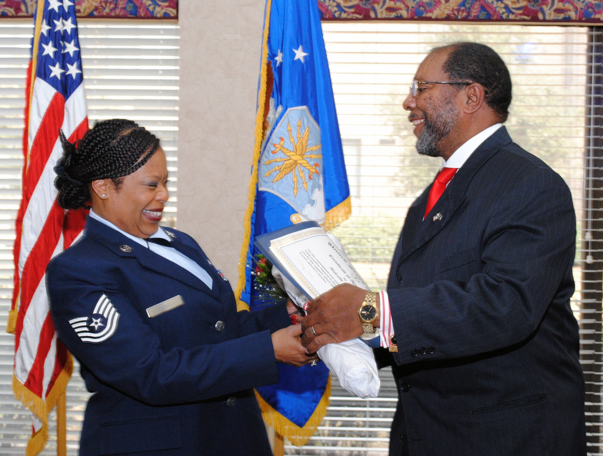 Tech. Sgt. Jessica King, 94 Services support flight NCOIC, presents her husband, Malcolm W. Bennett, with a bouquet of roses along with a certificate of appreciation for his years of support for his wife’s service to the Air Force Reserve.  