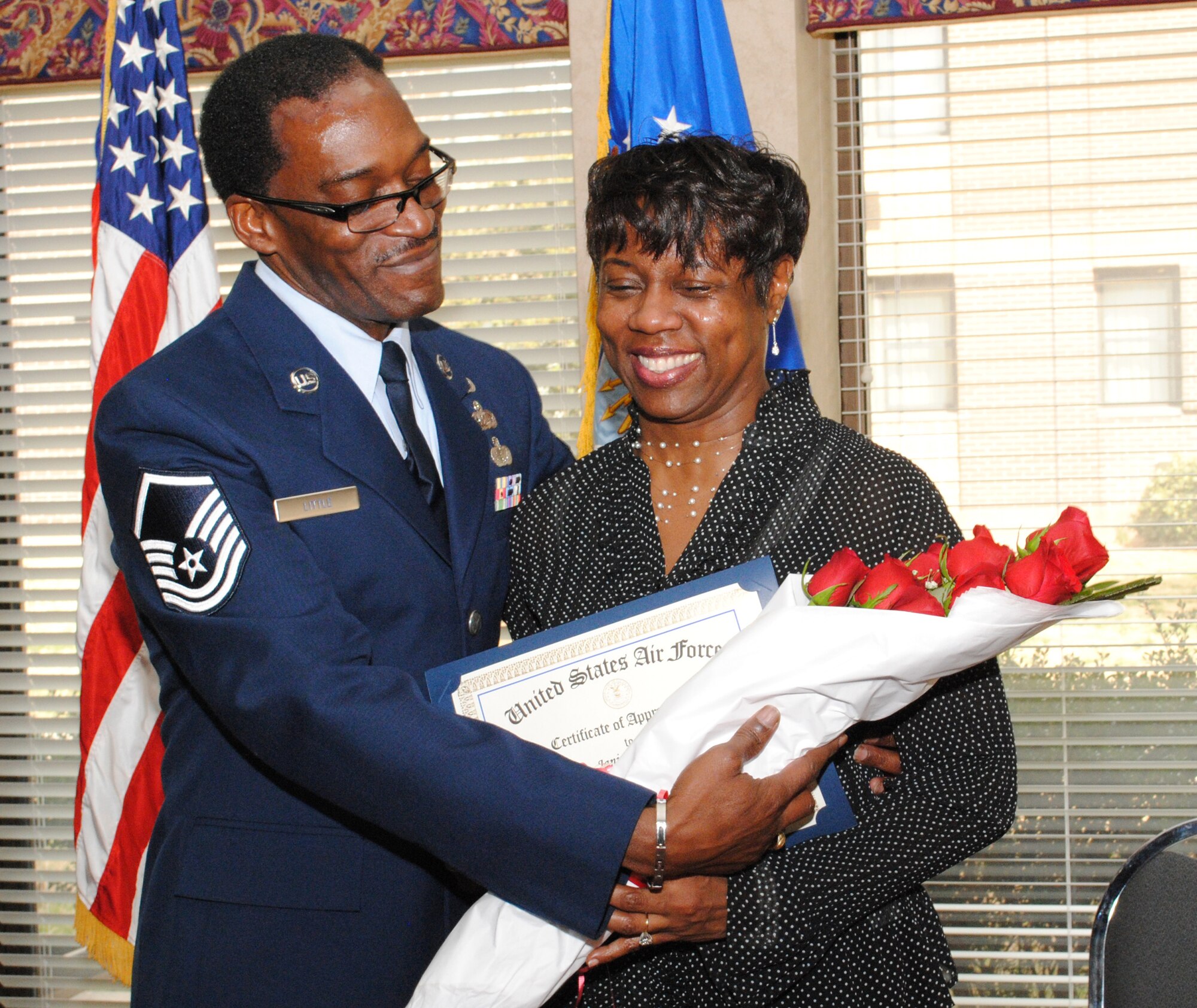 Master Sgt. Ron Little, 94th Services first sergeant, presents a bouquet of roses to his wife Janis, symbolizing her years of support for her husband’s service to the Air Force Reserve.  (U.S. Air Force photo/Master Sgt. Stan Coleman)  