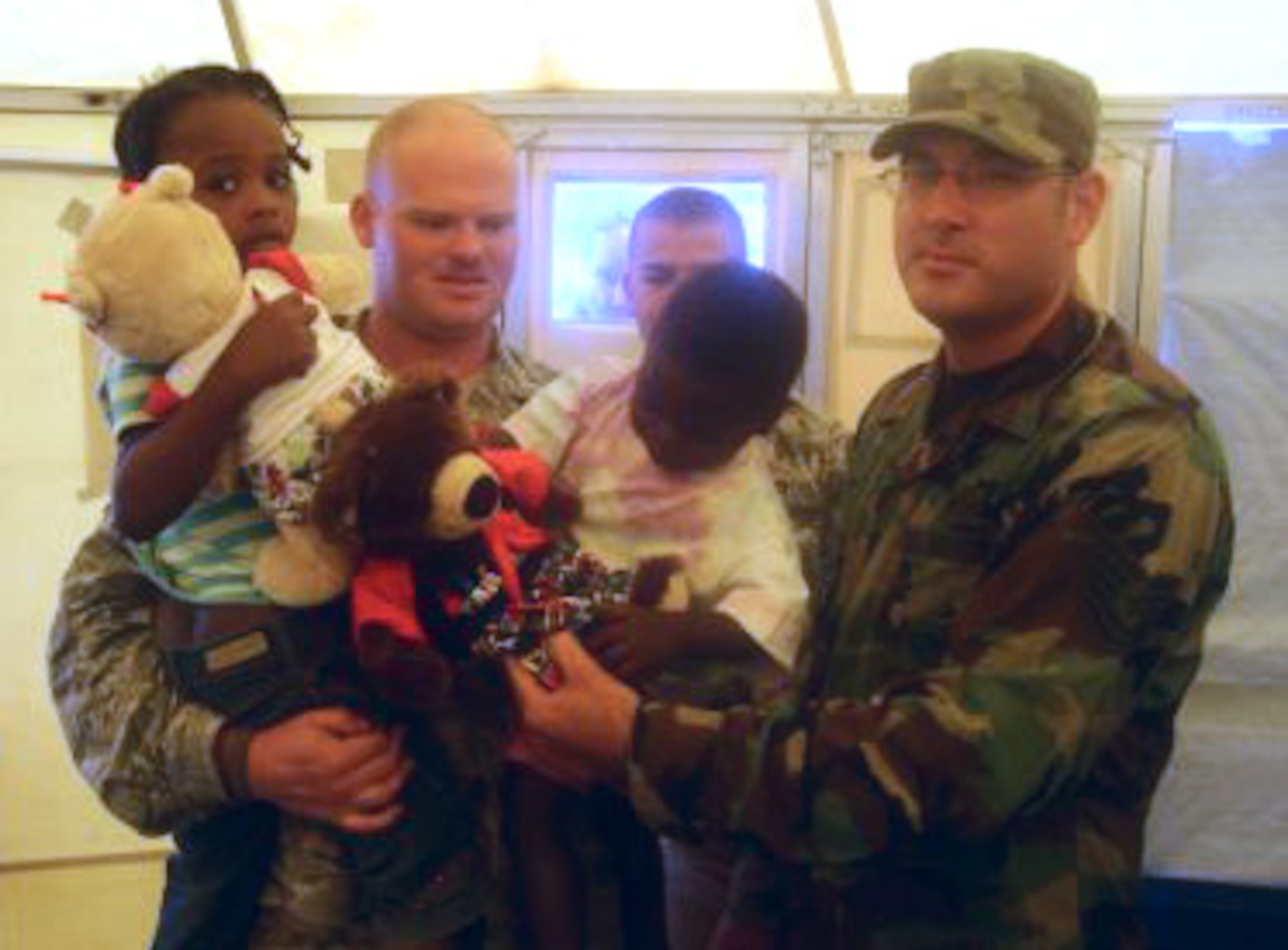 PORT-AU-PRINCE, Haiti – U.S. Air Force Servicemen, including Tech. Sgt. Kevin Hasselbach (right) from Langley Air Force Base, distribute stuffed animals to Haitian children March 4.  Airmen distributed toys to comfort the children of Port-Au-Prince following a devastating earthquake that stuck the region Jan. 12. (U.S. Air Force Courtesy Photo)