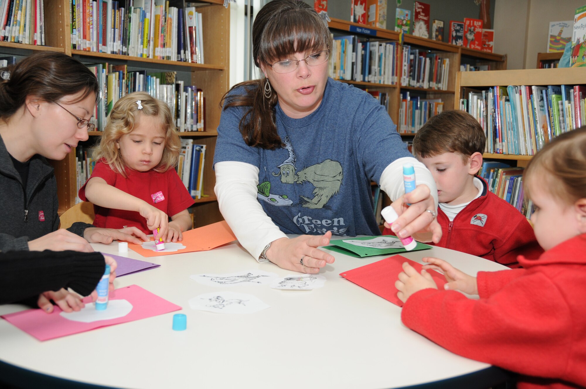 From left, Anna Christian and her 4-year-old daughter, Madison, and Ainsley Gottrich and her children, Ryan, 4, and Erin, 2, work on cards to celebrate the birthday of Dr. Seuss at McBride Library March 3, a day after his actual birthday.  Dr. Seuss was the pen name of Theodor Seuss Geisel, an American writer and cartoonist who published more than 60 children’s books.  He died in 1991 at the age of 87.  The children’s dads are Tech. Sgt. Allen Christian, 338th Training Squadron, and Lt. Col. Daniel Gottrich, 338th TRS commander.  (U.S. Air Force photo by Kemberly Groue)