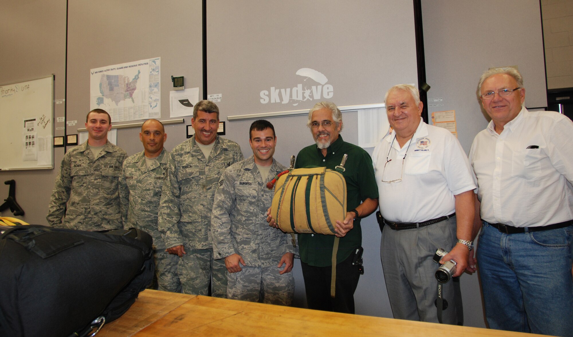 PATRICK AIR FORCE BASE, Fla. - The 920th Rescue Wing Air Crew Flight Equipment Technicians and the Brevard Veterans Memorial Center creators hold the packed parachute. The parachute will be on display at the museum. (U.S. Air Force Photo/Staff Sgt. Leslie Kraushaar) 