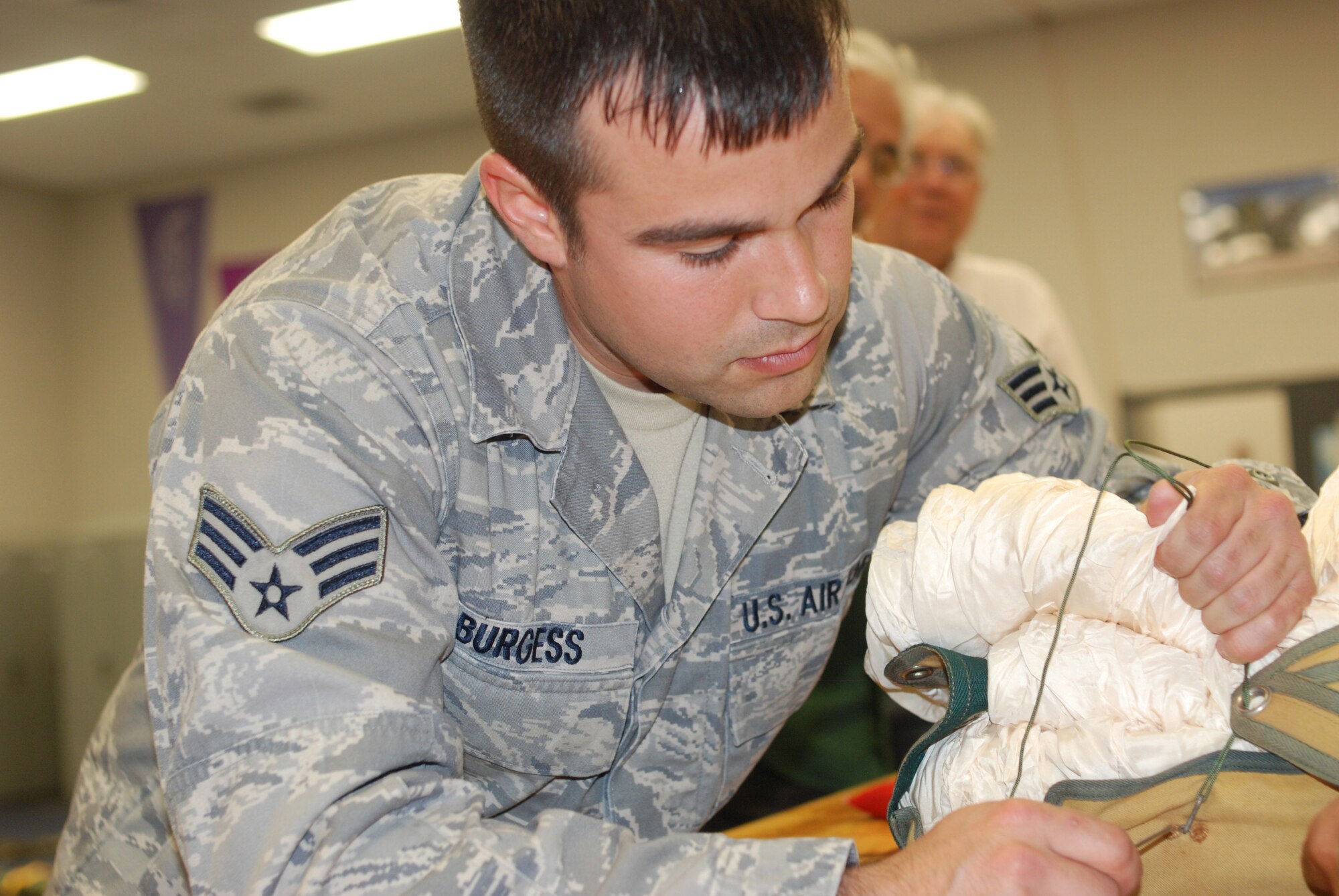 PATRICK AIR FORCE BASE, Fla. -  Air Force Reservist Senior Airman Jarrod Burgess , an aprentice with the  920th Rescue Wing's aircrew flight equipment (AFE), tightens up the thread that holds the parachute together. The reservists that make up the 920th RQW's AFE are highly trained as parachute packers and a host of other equipment.  (U.S. Air Force photo/Staff Sgt. Leslie Kraushaar)