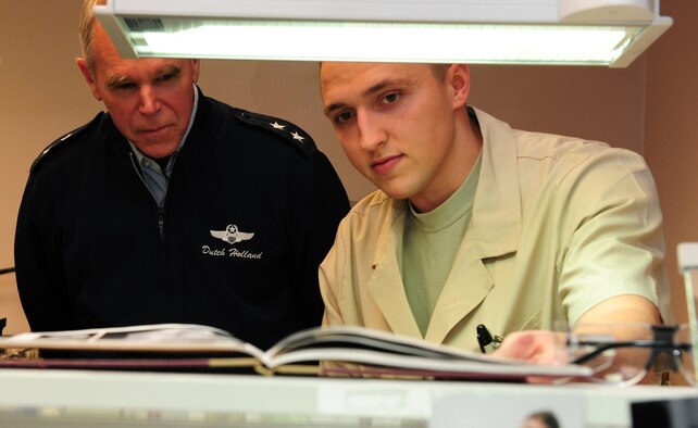 SHAW AIR FORCE BASE, S.C. -- Maj. Gen. William Holland, Ninth Air Force commander, and Senior Airman Justin Rhodes, 20th Dental Squadron, look at pictures of dental caps at the 20th DS, March 8. After taking command of Ninth Air Force, General Holland and his wife, Norma, take an official tour of the 20th Fighter Wing. (U.S. Air Force photo/Airman 1st Class Neil D. Warner)