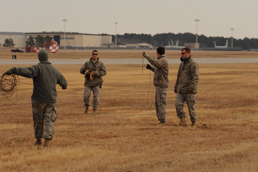 Airmen from the 4th Civil Engineer Squadron explosive ordnance disposal flight pre-position detonation cord for a simulated strafing run on Seymour Johnson Air Force Base, N.C., March 4, 2010. Detonation cord is a thin, flexible tube with an explosive core. (U.S. Air Force photo/Staff Sgt. Courtney Richardson)