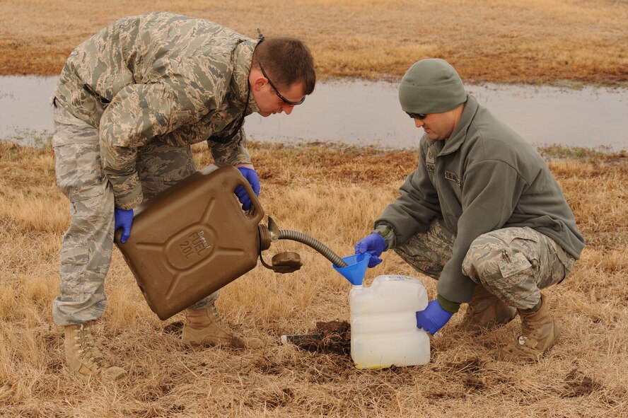 Airman 1st Class Joshua Lail and Tech. Sgt. Chad McCrackin, 4th Civil Engineer Squadron explosive ordnance disposal technicians, fill water jugs with fuel for an airpower demonstration on Seymour Johnson Air Force Base, N.C., March 4, 2010. The EOD Airmen place the fuel-filled jugs on top of a C4 block to add fire effects to the demonstration. Lail is from Hickory, N.C. and McCrackin is a reservist from Charleston, S.C., and hails from Myrtle Beach, S.C. (U.S. Air Force photo/Staff Sgt. Courtney Richardson)