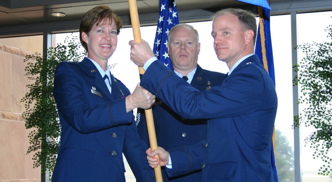 310th Space Wing commander Col. Karen Rizzuti passes the 310th Aerospace Medicine Flight guideon to Lt. Col. David Schaefer during a change of command ceremony on Mar. 8. Colonel Schaefer succeeds Lt. Col. John Langell. The event took place at the 50th Space Wing headquarters at Schriever Air Force Base, Colo. (U.S. Air Force photo by Tech. Sgt. Scott P. Farley)