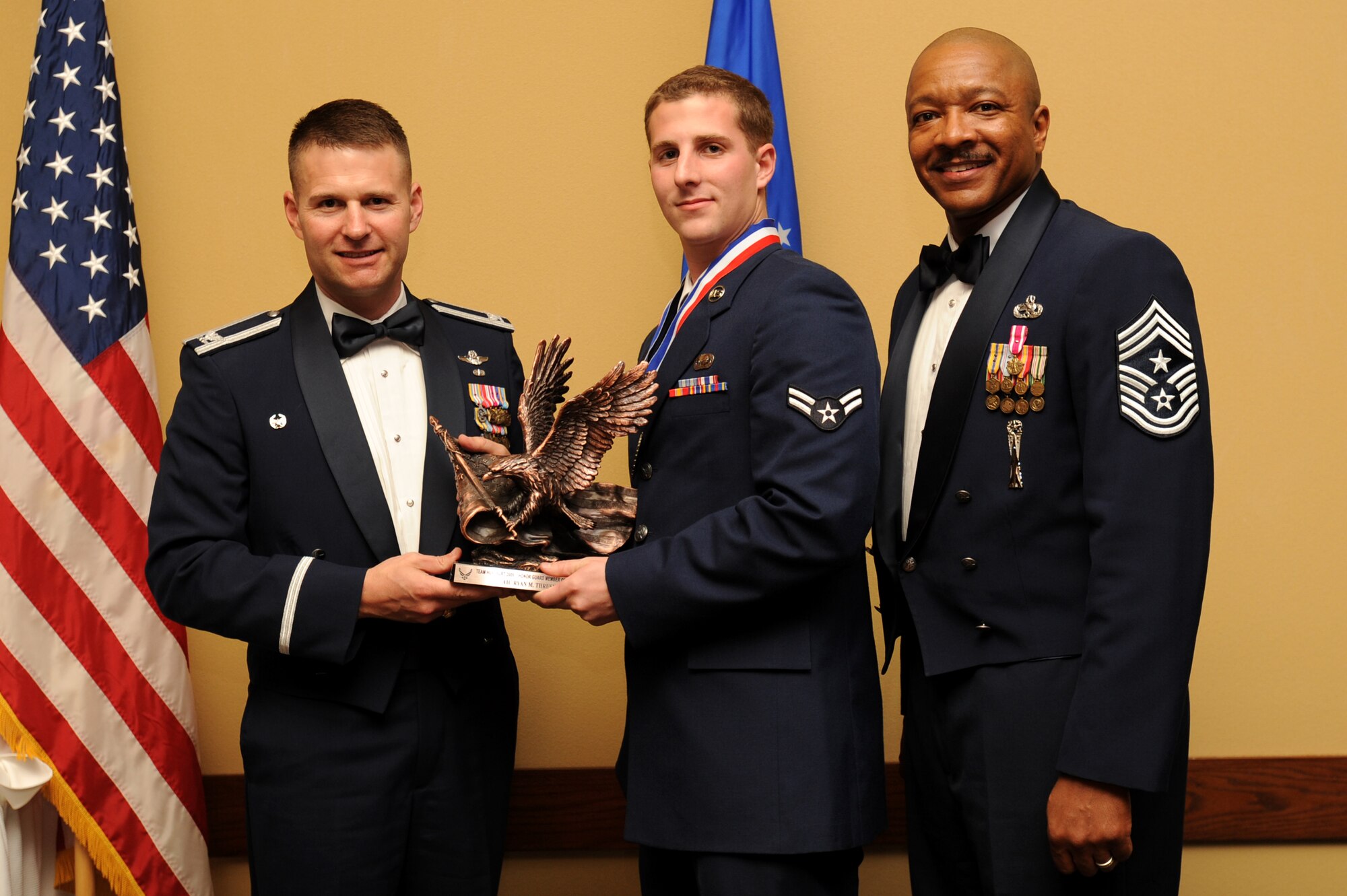Airman 1st Class Ryan Thrush, 1st Special Operations Support Squadron, center, accepts the honor guard category award from Col. Greg Lengyel, 1st Special Operations Wing commander, and Chief Master Sgt. Dexter Mitchell, 1st SOW command chief, at the 2009 Annual Team Hurlburt Awards Banquet at the Hurlburt Field Soundside Club Mar. 4. (U.S. Air Force photo by Senior Airman Matthew Loken)