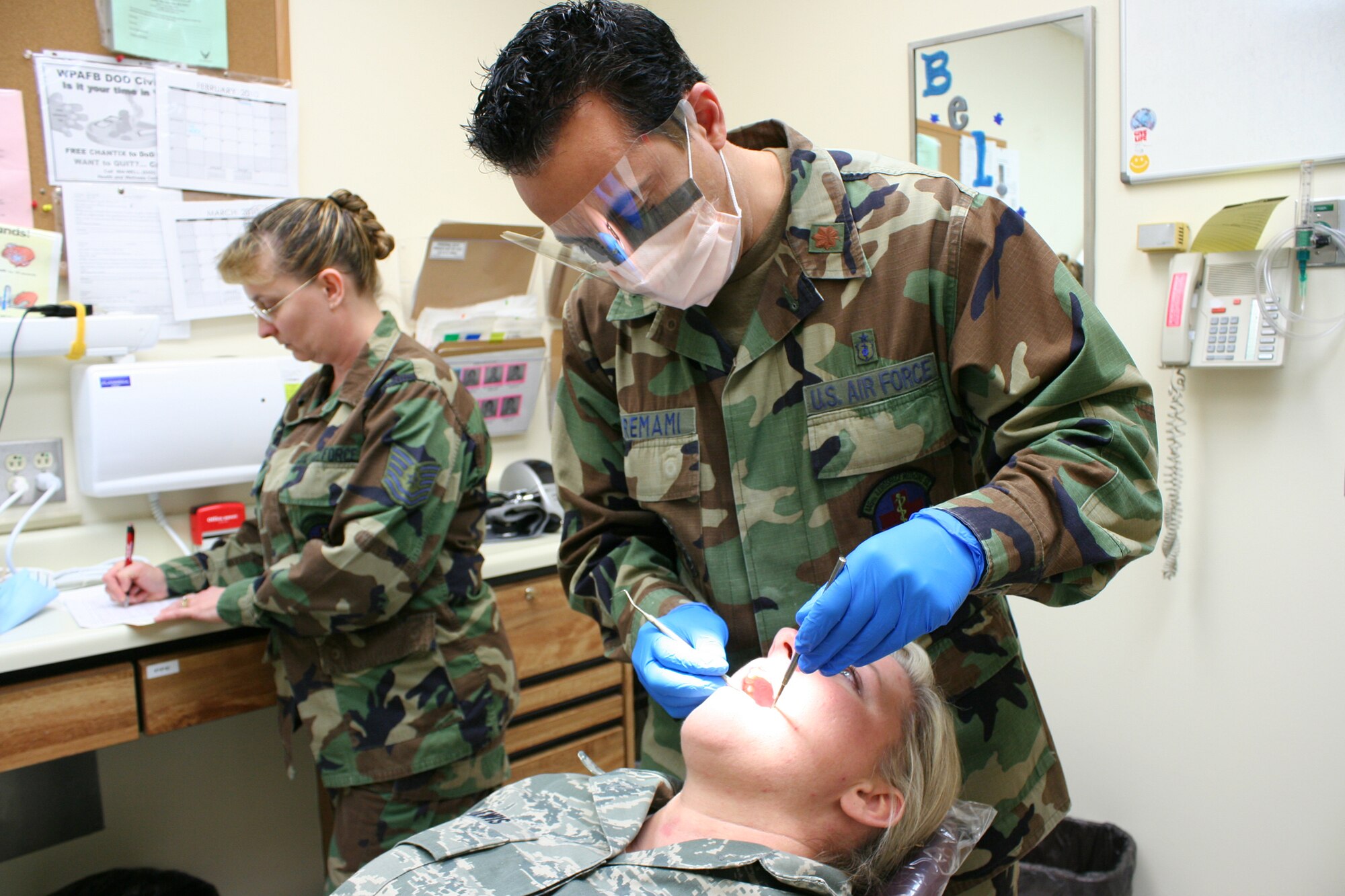 WRIGHT-PATTERSON AIR FORCE BASE, Ohio – Maj. Ali Miremami, 445th Aerospace Medicine Squadron, performs a dental exam on Senior Airman Roxanne Lewis, 445th Services Squadron, as Tech. Sgt. Barb Adams, 445th Aerospace Medicine Squadron, writes down dental information as part of Airman Lewis’s annual Reserve Component Periodic Health Assessment during the March 6 unit training assembly. Reservists are required to have an annual RCPHA, which consists of a medical and dental exam, to maintain medical readiness for deployment and worldwide duty. (U.S. Air Force photo/Tech. Sgt. Jeremy Caskey)