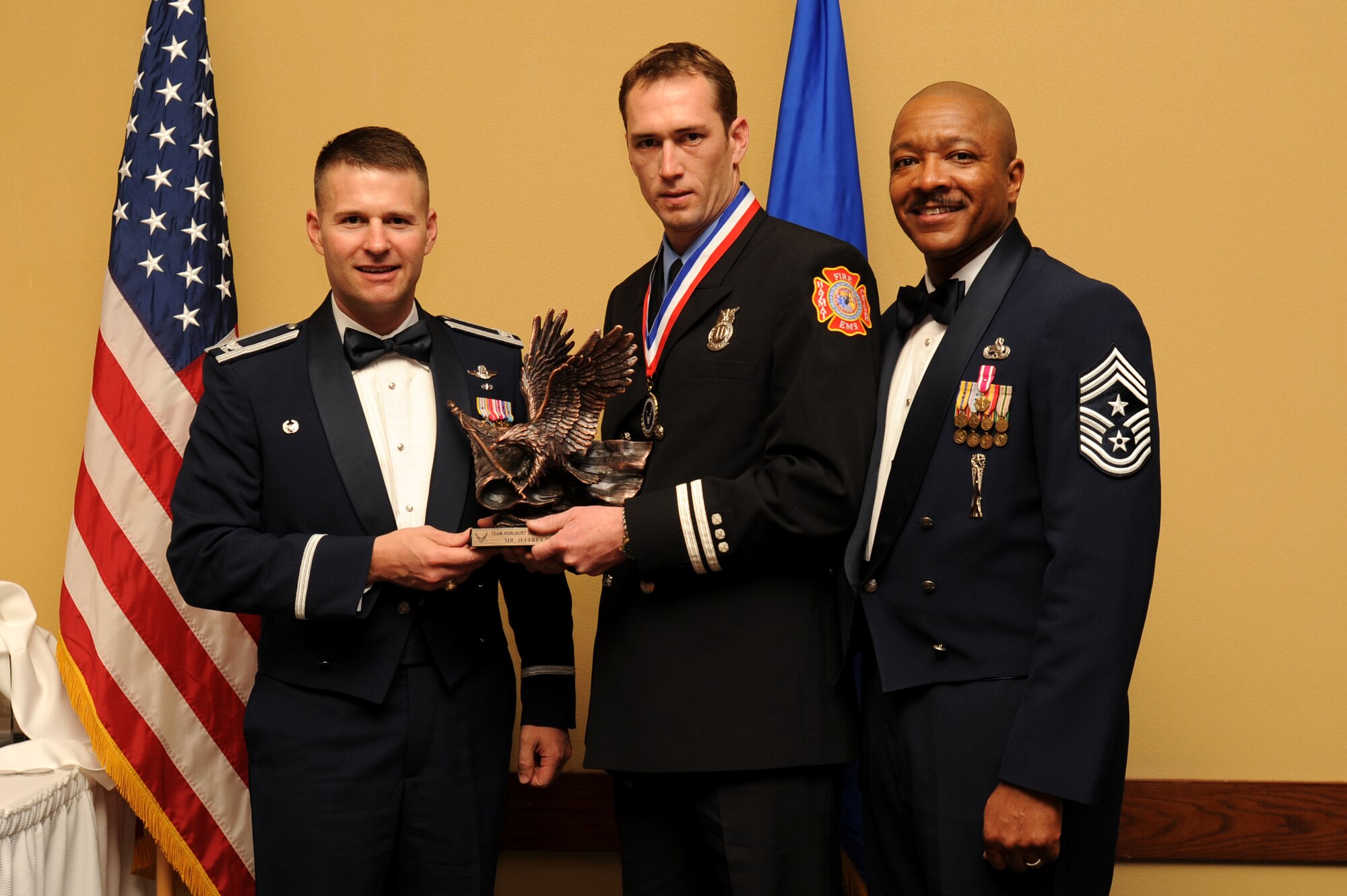 Jeffrey Higdon, 1st Special Operations Civil Engineering Squadron, center, accepts the GS 1-8 winner award from Col. Greg Lengyel, 1st Special Operations Wing commander, and Chief Master Sgt. Dexter Mitchell, 1st SOW command chief, at the 2009 Annual Team Hurlburt Awards Banquet at the Hurlburt Field Soundside Club Mar. 4. (U.S. Air Force photo by Senior Airman Matthew Loken)