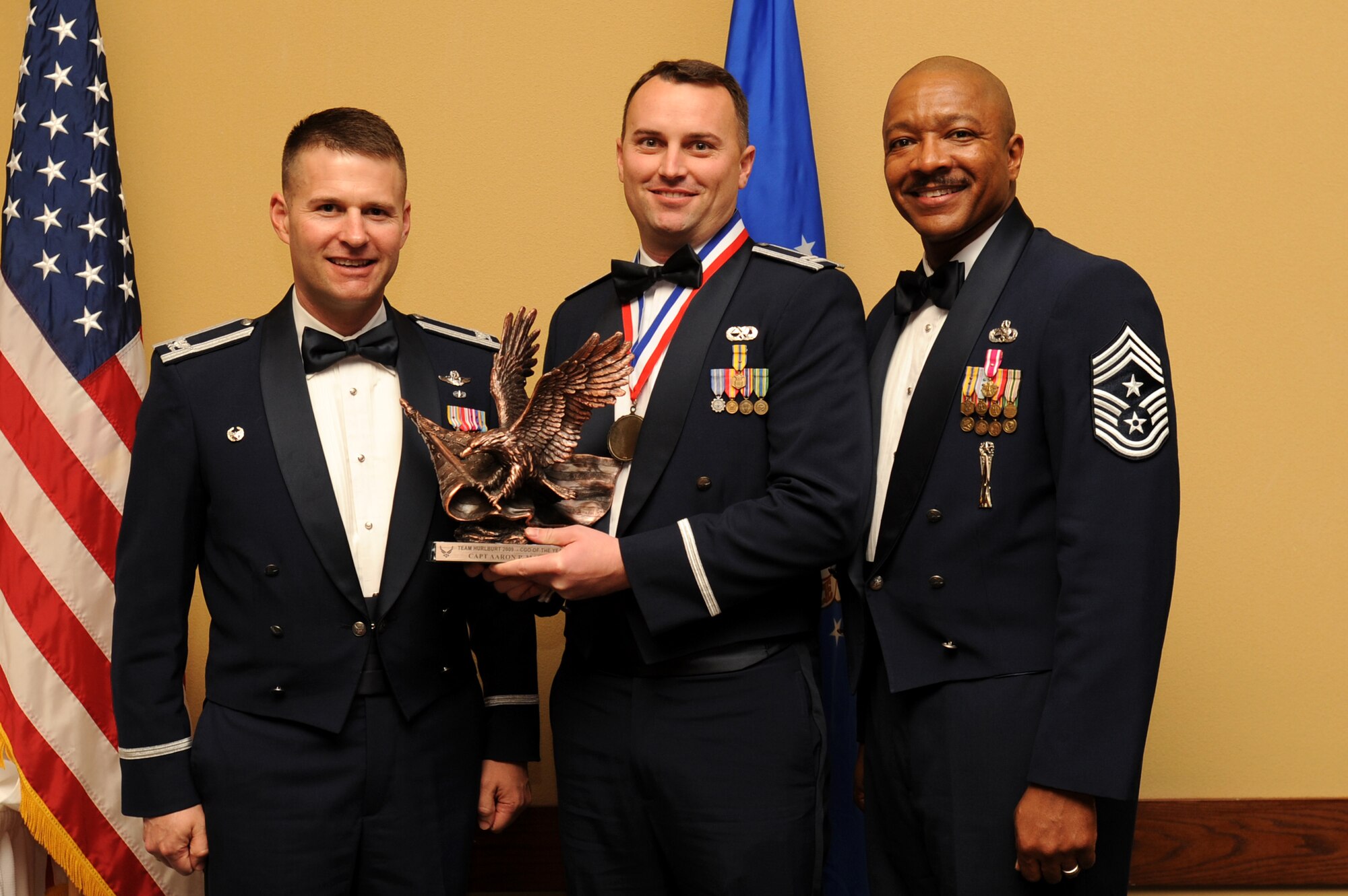 Capt. Aaron Martin, 1st Special Operations Component Maintenance Squadron, center, accepts the company grade officer annual award from Col. Greg Lengyel, 1st Special Operations Wing commander, and Chief Master Sgt. Dexter Mitchell, 1st SOW command chief, at the 2009 Annual Team Hurlburt Awards Banquet at the Hurlburt Field Soundside Club Mar. 4. (U.S. Air Force photo by Senior Airman Matthew Loken)