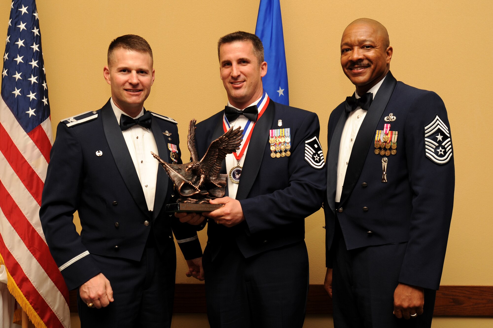 Master Sgt. Lance Hopping, 1st Special Operations Support Squadron, center, accepts the First Sergeant annual award from Col. Greg Lengyel, 1st Special Operations Wing commander, and Chief Master Sgt. Dexter Mitchell, 1st SOW command chief, at the 2009 Annual Team Hurlburt Awards Banquet at the Hurlburt Field Soundside Club Mar. 4. (U.S. Air Force photo by Senior Airman Matthew Loken)