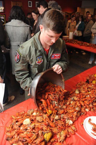 First Lt. Justin Andress, 333rd Fighter Squadron student weapon systems officer, pours crawfish onto a table during the squadron's Basic Course 09-CBE Red Carpet Day lunch at Seymour Johnson Air Force Base, N.C., March 5, 2010.  More than 100 family member and friends participated in the Red Carpet Day events. (U.S. Air Force photo/Tech. Sgt. Lesley Waters) 