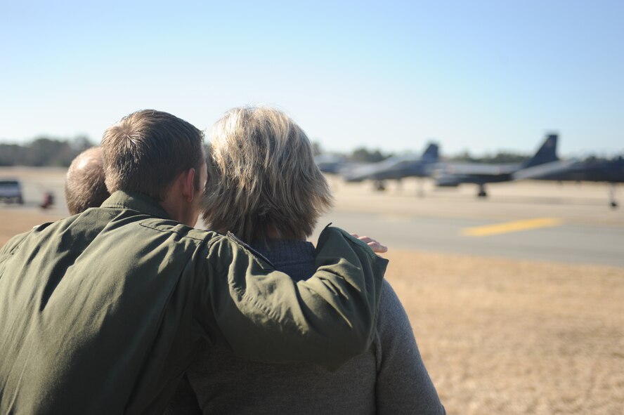 First Lt. Grant Saum, 333rd Fighter Squadron student pilot, puts his arms around his parents, Joe and Wanda Saum, during the squadron's Basic Course 09-CBE Red Carpet Day at Seymour Johnson Air Force Base, N.C., March 5, 2010.  Saum is one of 24 students who completed the nine-month pilot and weapon systems officer B-Course. Students and guests played with the simulators, tried on night vision goggles, toured the air traffic control tower and viewed F-15E Strike Eagle static displays.  The Saum?s are from Findlay, Ohio.  (U.S. Air Force photo/Tech. Sgt. Lesley Waters)