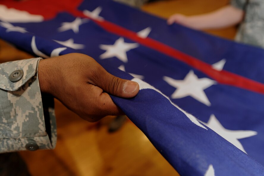 WHITEMAN AIR FORCE BASE, Mo., - Members from the 509th Communications Squadron ceremoniously fold a garrison-size flag inside the fitness center, here, March 9, 2010.  Capt.  Jason Mayne, 509th Communications Squadron Officer, currently deployed to Kuwait, rescued the two flags from disposal to be displayed at the new 509th CS consolidated building in November 2010. (U.S. Air Force photo/Senior Airman Jessica Mae Snow) (Released)