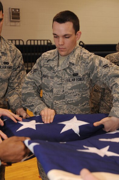 WHITEMAN AIR FORCE BASE, Mo., - Airman 1st Class Zachary Wirfs, 509th Bomb Wing Communication Squadron, smoothes a fold on a garrison-size flag inside the fitness center, here, March 9, 2010.  Capt.  Jason Mayne, 509th Communications Squadron Officer, currently deployed to Kuwait, rescued the two flags from disposal for display at the new 509th CS consolidated building in November 2010. (U.S. Air Force photo/Senior Airman Jessica Mae Snow) (Released)