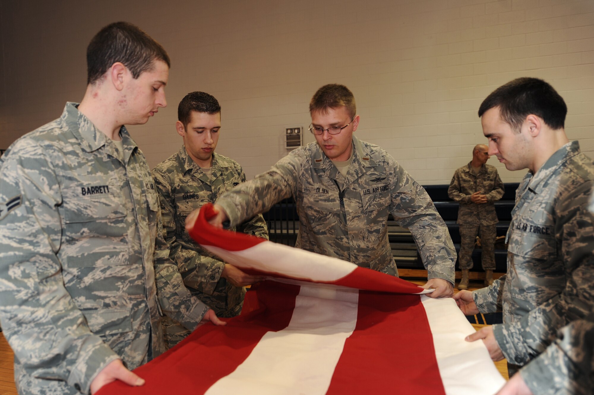 WHITEMAN AIR FORCE BASE, Mo., - 2nd Lt. William Olsen, 509th Communications Squadron, ceremoniously folds a garrison-size flag inside the fitness center, here, March 9, 2010.  Capt.  Jason Mayne, 509th Communications Squadron Officer, currently deployed to Kuwait, rescued the two flags from disposal for display at the new 509th CS consolidated building in November 2010. (U.S. Air Force photo/Senior Airman Jessica Mae Snow) (Released)