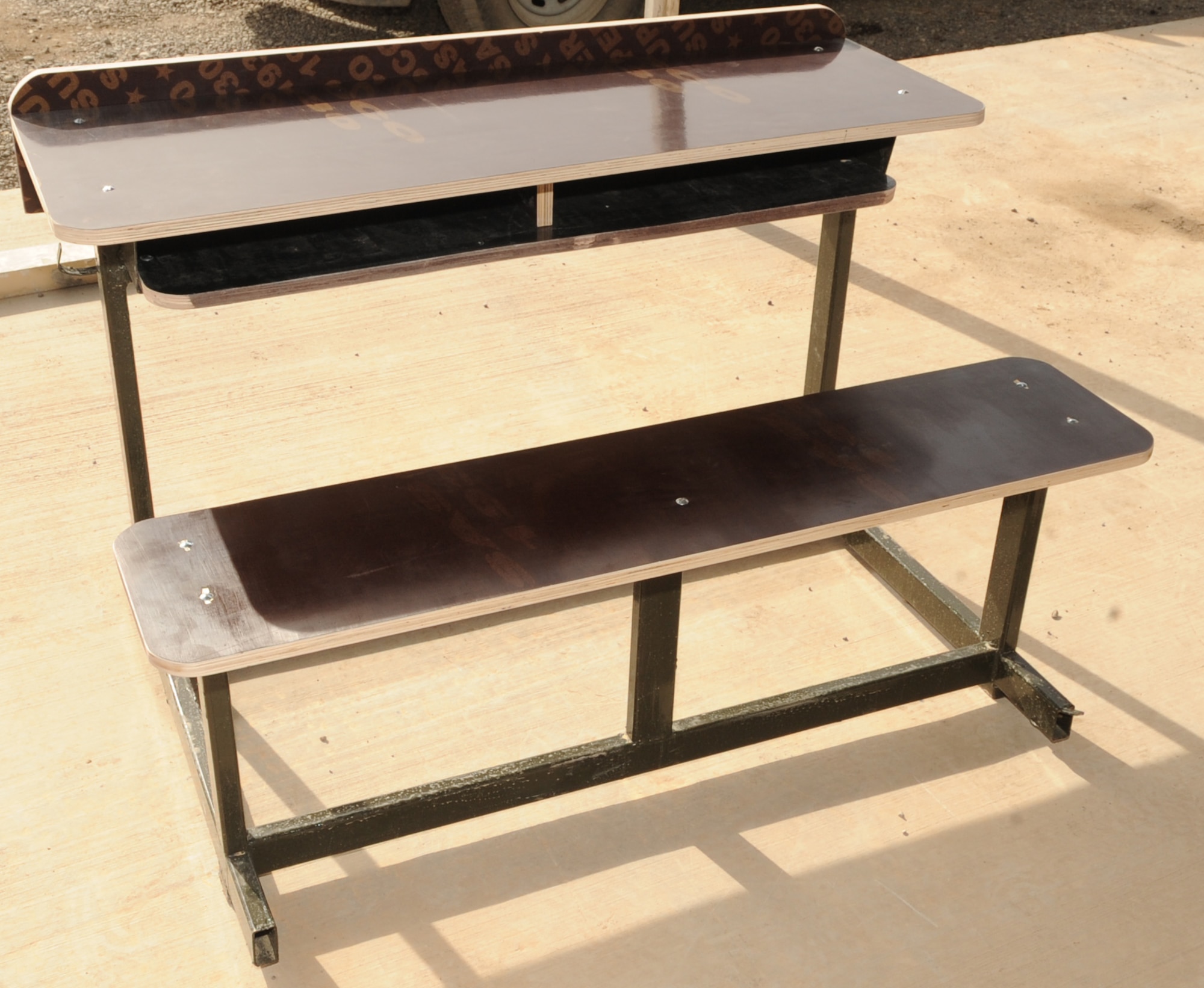 Volunteers from the 506th Expeditionary Civil Engineer Squadron, sand down pieces of wood during assembly of school desks for local Iraqi children on March 6, 2010 at Kirkuk Regional Air Base, Iraq.  Out of their goal of 100 desks, 25 of them have already been assembled and are ready to be delivered to schools in need. (U.S. Air Force photo/Staff Sgt. Tabitha Kuykendall/Released)	       