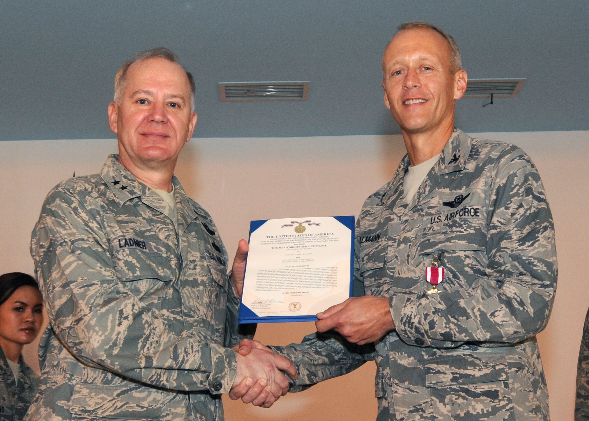 CAMP LEMONNIER, Djibouti – Maj. Gen. Ronald Ladnier (Left), 17th Air Force (Air Forces Africa) commander, presents a Meritorious Service Medal to Col. Jon Ullmann during the 449th Air Expeditionary Group’s Change of Command ceremony here March 9. Colonel Ullmann, the outgoing commander of the 449th Air Expeditionary Group, was cited for excellent leadership during his six months in command of the group. He now returns to his position in charge of Combat Operations at the 617th Air and Space Operations Center at Ramstein Air Base. Col. Matthew Smith, who has been heading up Combat Operations at the 617th, took command at the 449th during the ceremony. The 449th, part of AFAFRICA at Ramstein, is responsible for personnel recovery and related air operations in Horn of Africa. (U.S. Air Force photo by Staff Sgt. Robert Barnett)