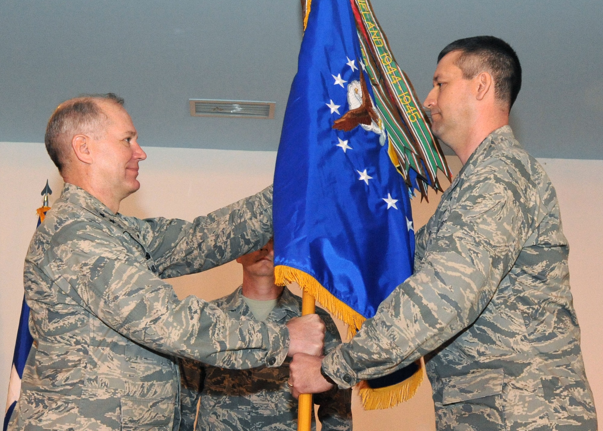 CAMP LEMONIER, Djibouti -- Maj. Gen. Ronald Ladnier (left), commander of 17th Air Force (Air Forces Africa), passes the 449th Air Expeditionary Group guidon to new group Commander, Col. Matthew Smith, in a change of command ceremony March 9 at Camp Lemonier, Djibouti. At home station, Colonel Smith is the chief of Combat Operations for the 617th Air and Space Operations Center at Ramstein. Ougoing Commander, Colonel Ullmann, now resumes his position as the head of Combat Operations at the 617th. Colonel Ullmann was cited by General Ladnier for his “excellent leadership” and received the Meritorious Service Medal for his tenure at the 449th. The 449th, part of AFAFRICA at Ramstein, is responsible for personnel recovery and related air operations in Horn of Africa. (U.S. Air Force photo by Staff Sgt. Robert Barnett)